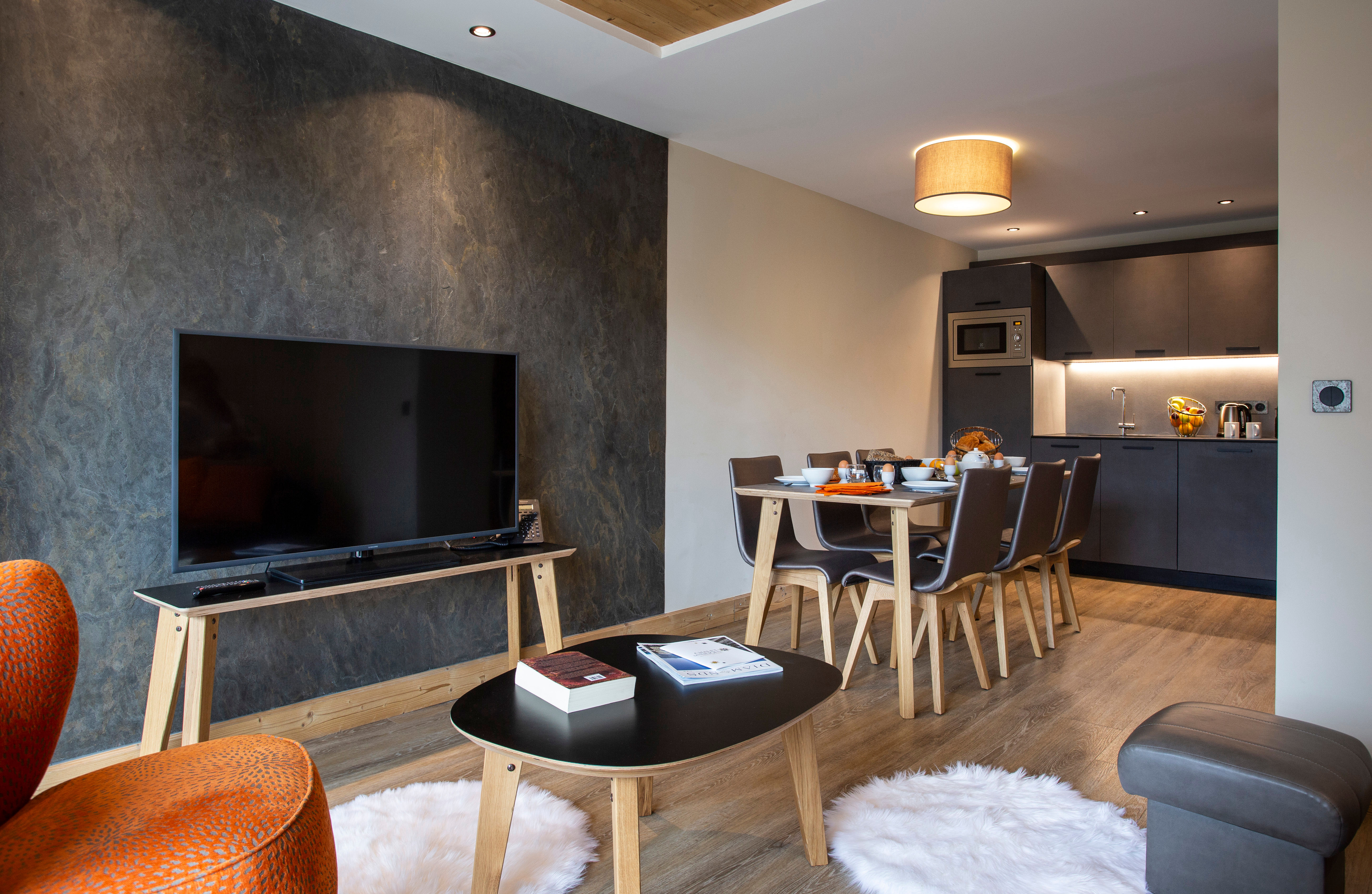 image Spacious living area with designer furnishings and cinematic TV setup, blending luxury with comfort.