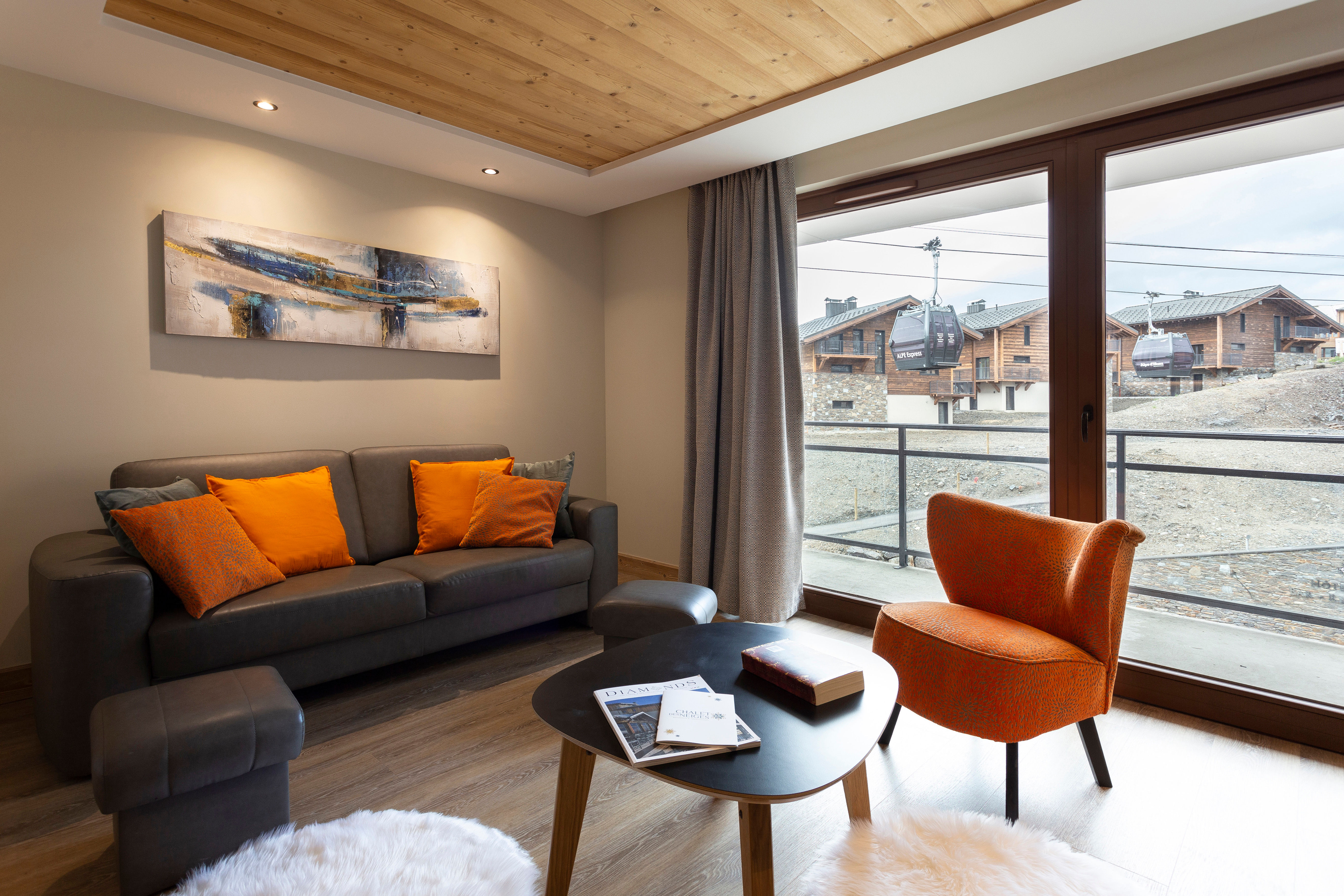 image Elegant alpine living room with warm wood finishes and direct balcony access offering panoramic mountain views.