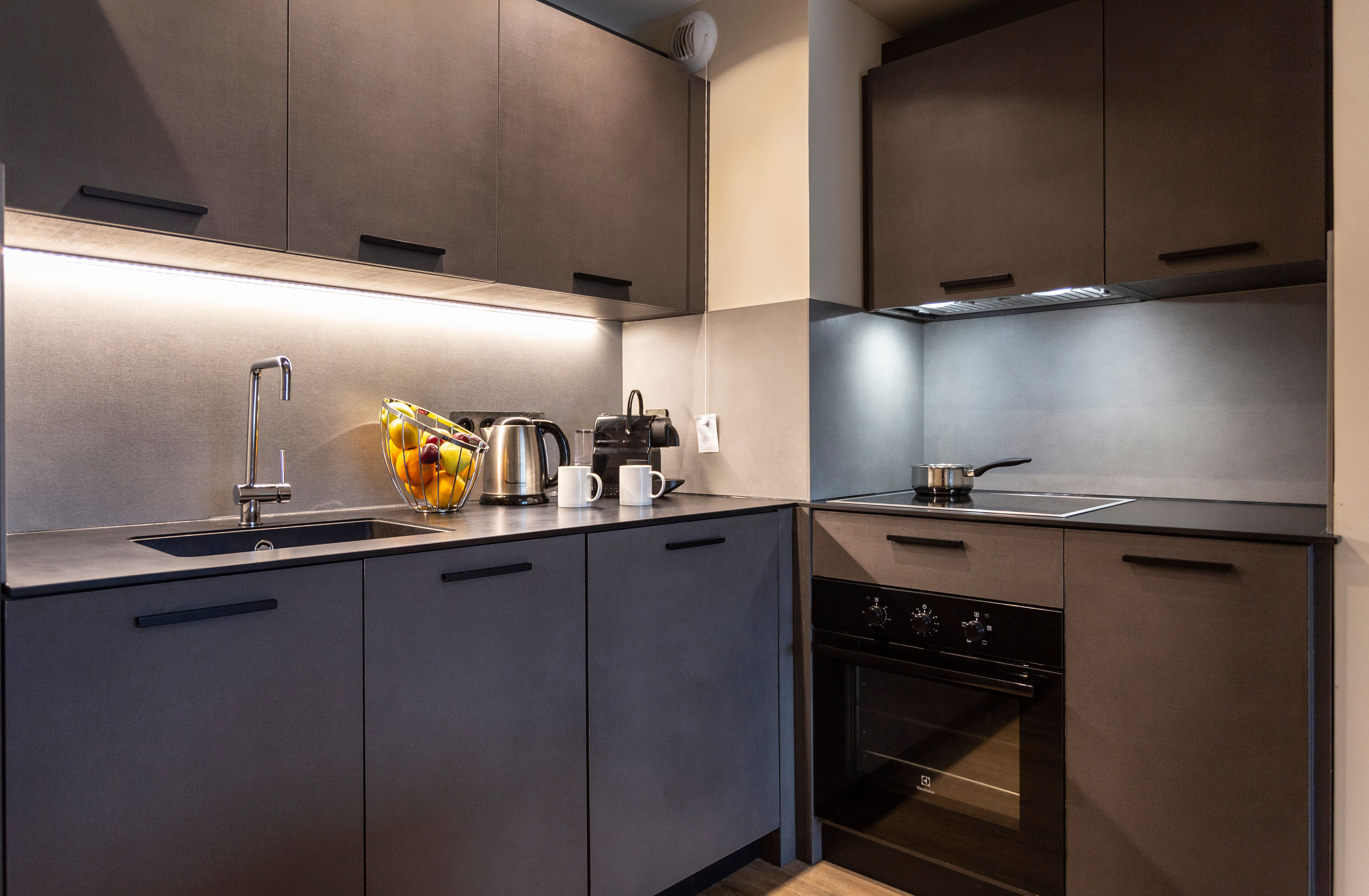 image Sleek matte cabinetry and underlit counters elevate this gourmet kitchen’s modern mountain charm.