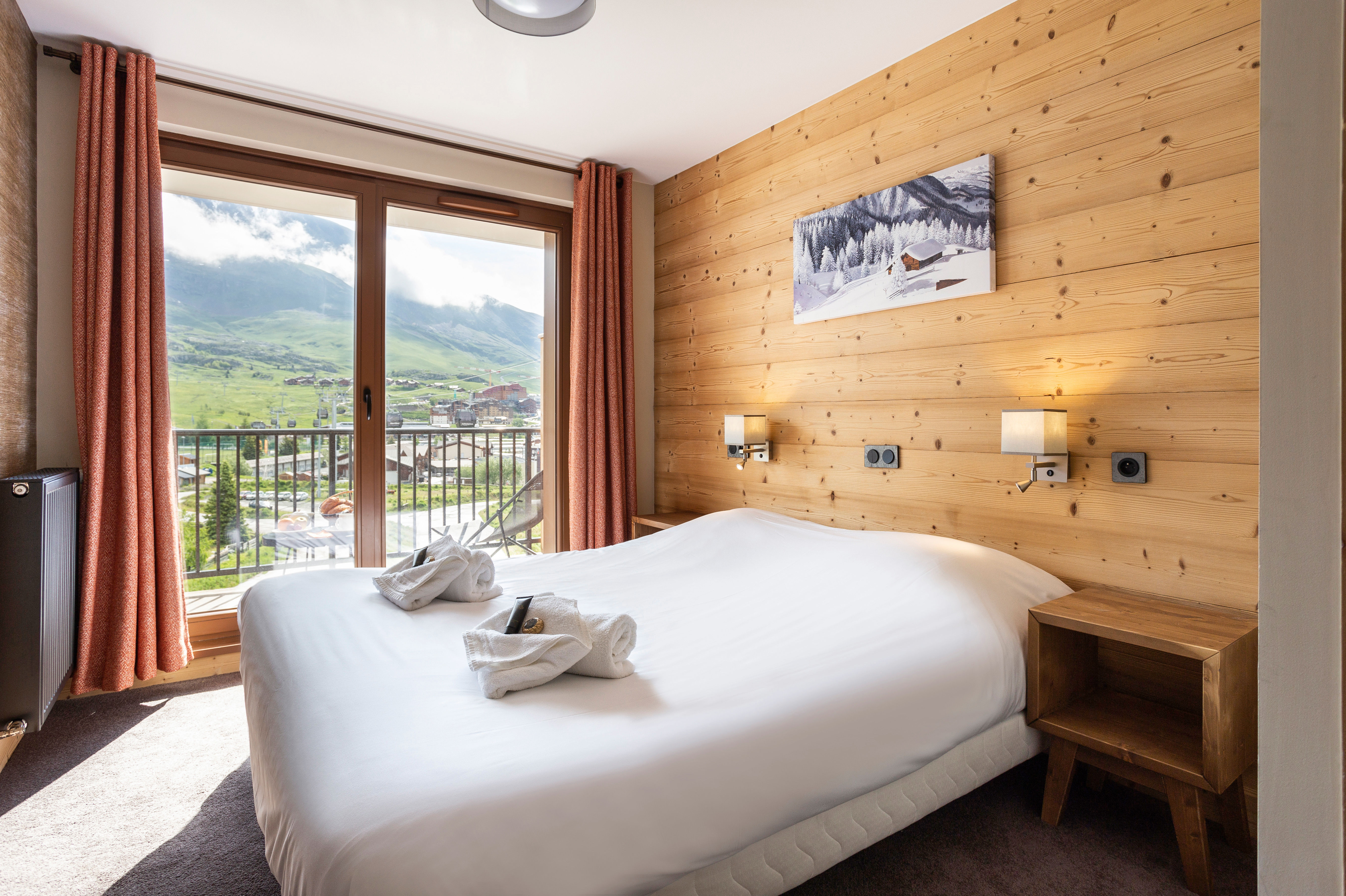 image Inviting bedroom wrapped in natural wood, featuring large windows and scenic views.