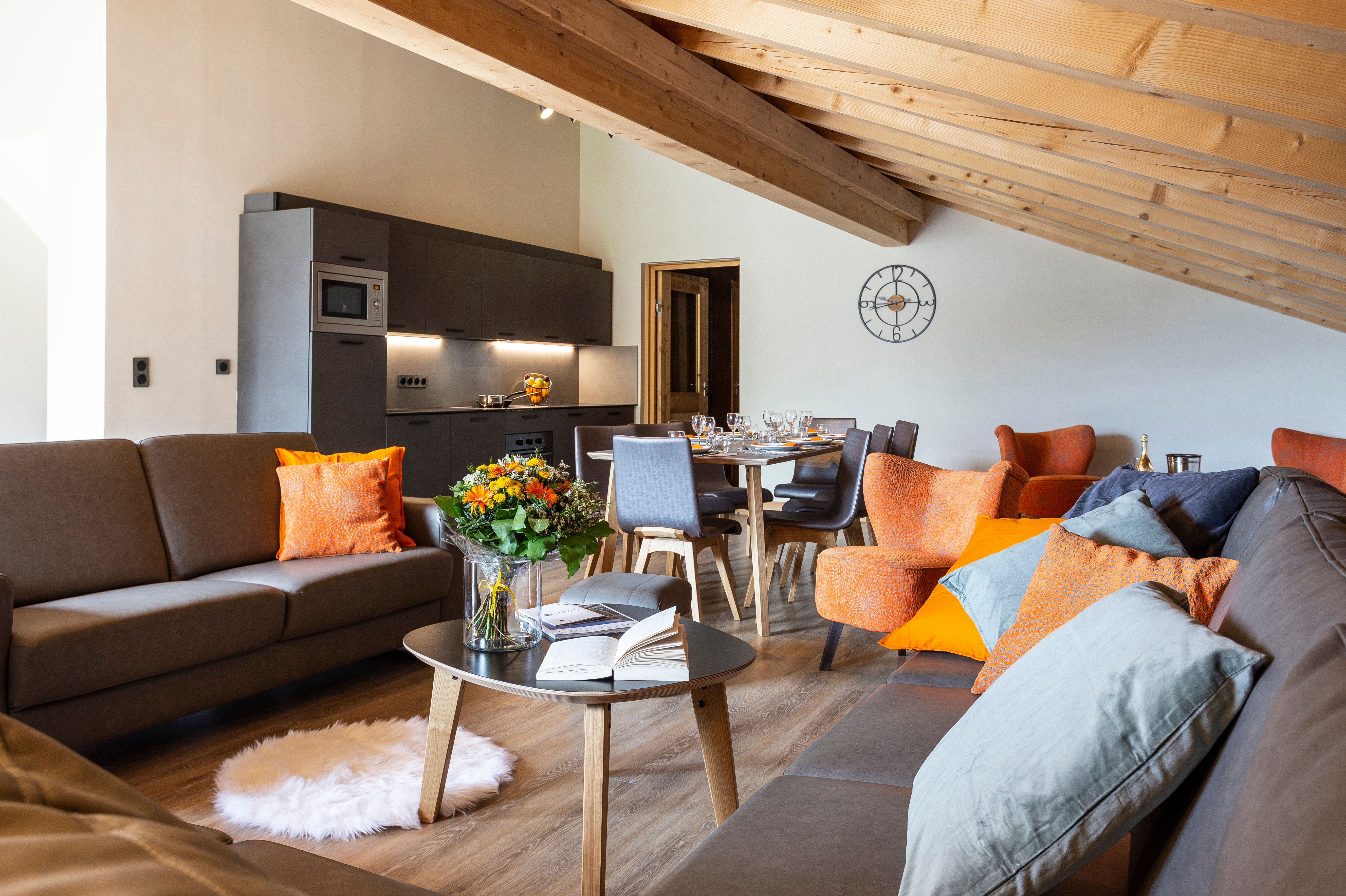 image Chic and airy living space with rustic beams, pops of color, and sweeping skylights.
