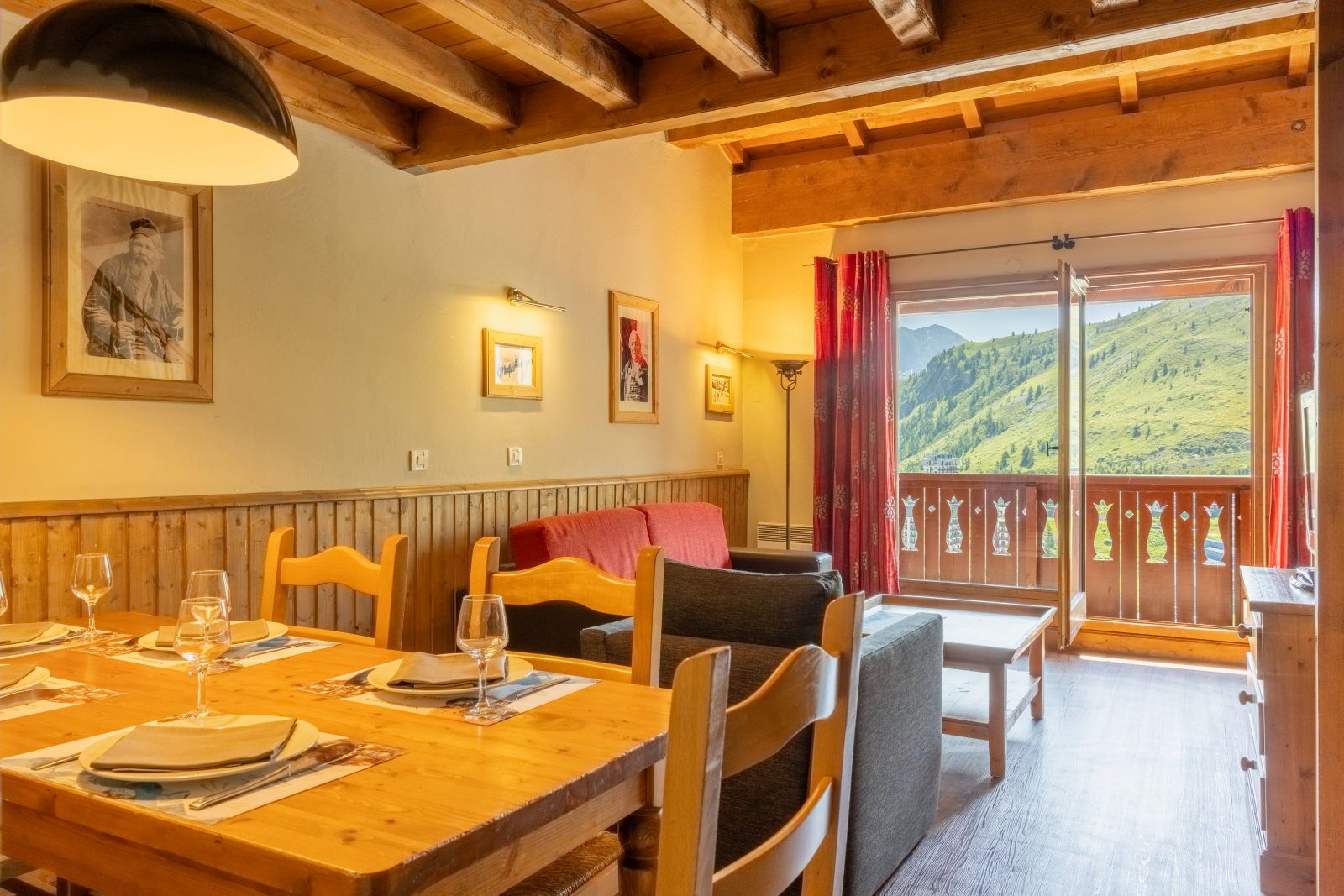 image Dining area with a wooden table, chairs, and large windows framing scenic mountain views