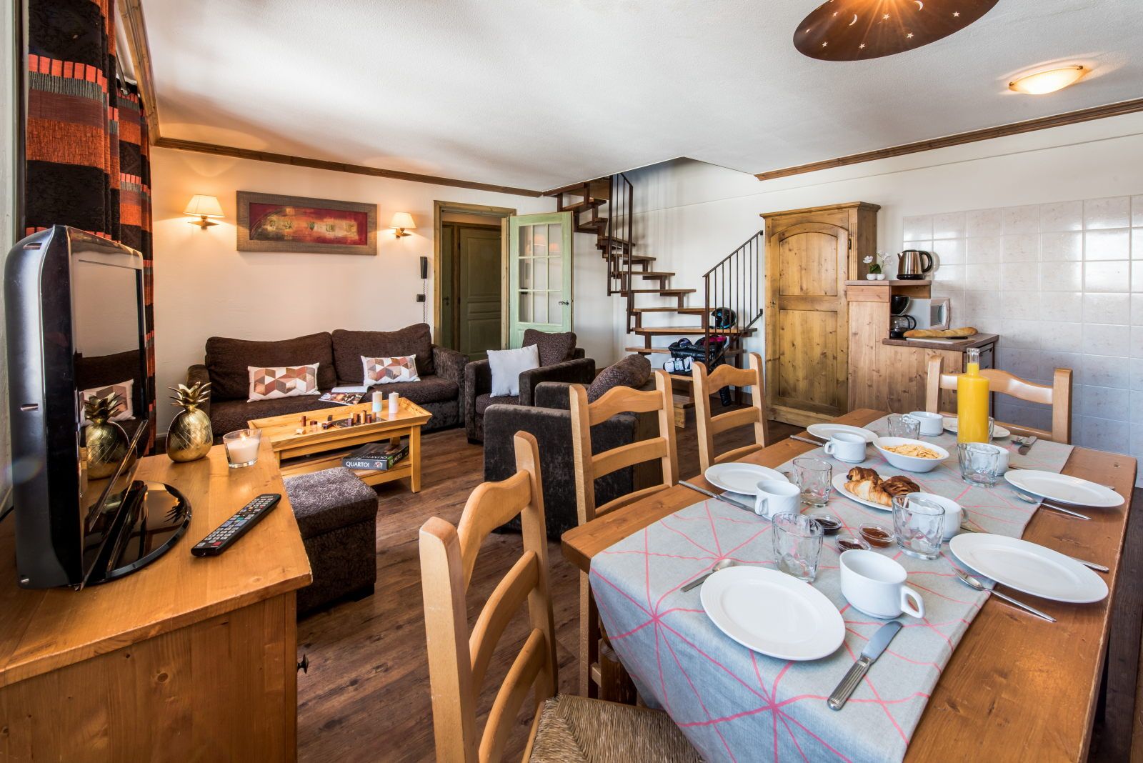 image Open-plan living area with sofas, dining table, staircase, and kitchen visible — great layout for groups