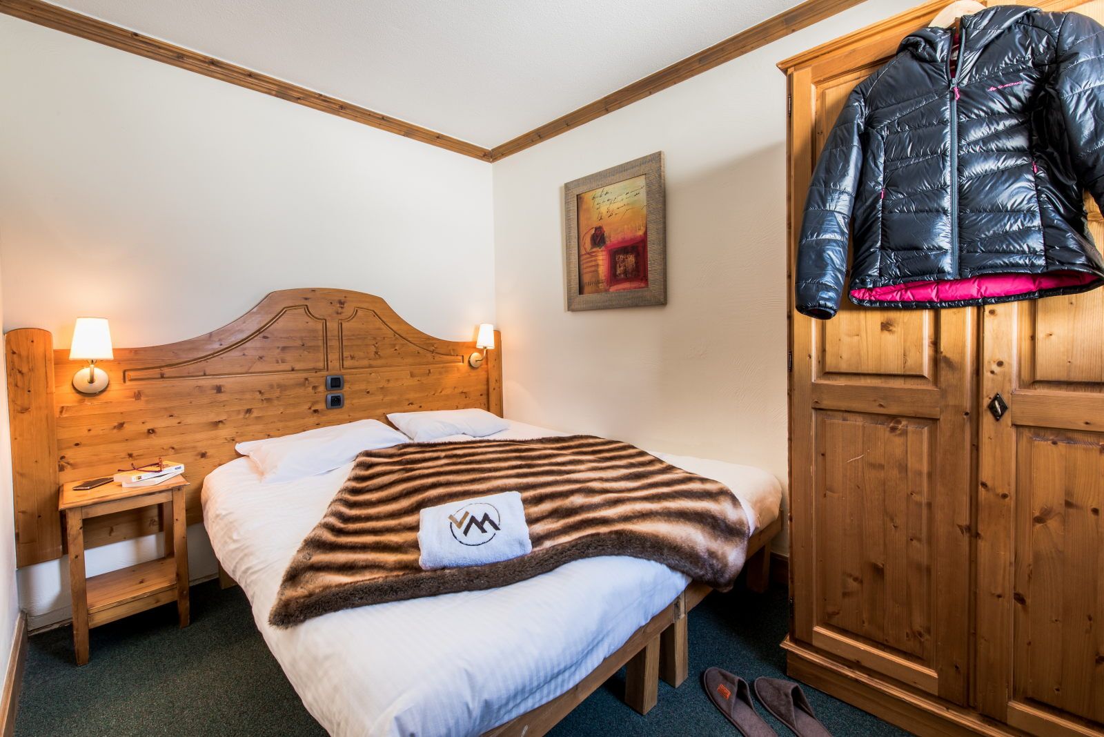 image Bedroom with warm wooden furnishings, a cosy blanket, and a wardrobe — made for a restful night