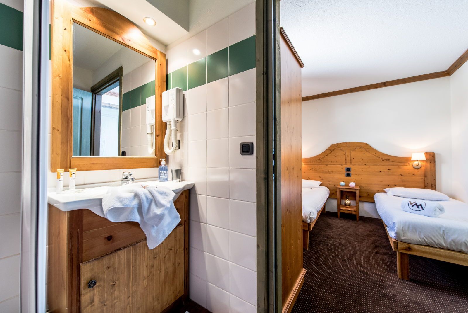 image Bathroom with sink and mirror adjoining the twin bedroom — a convenient ensuite layout
