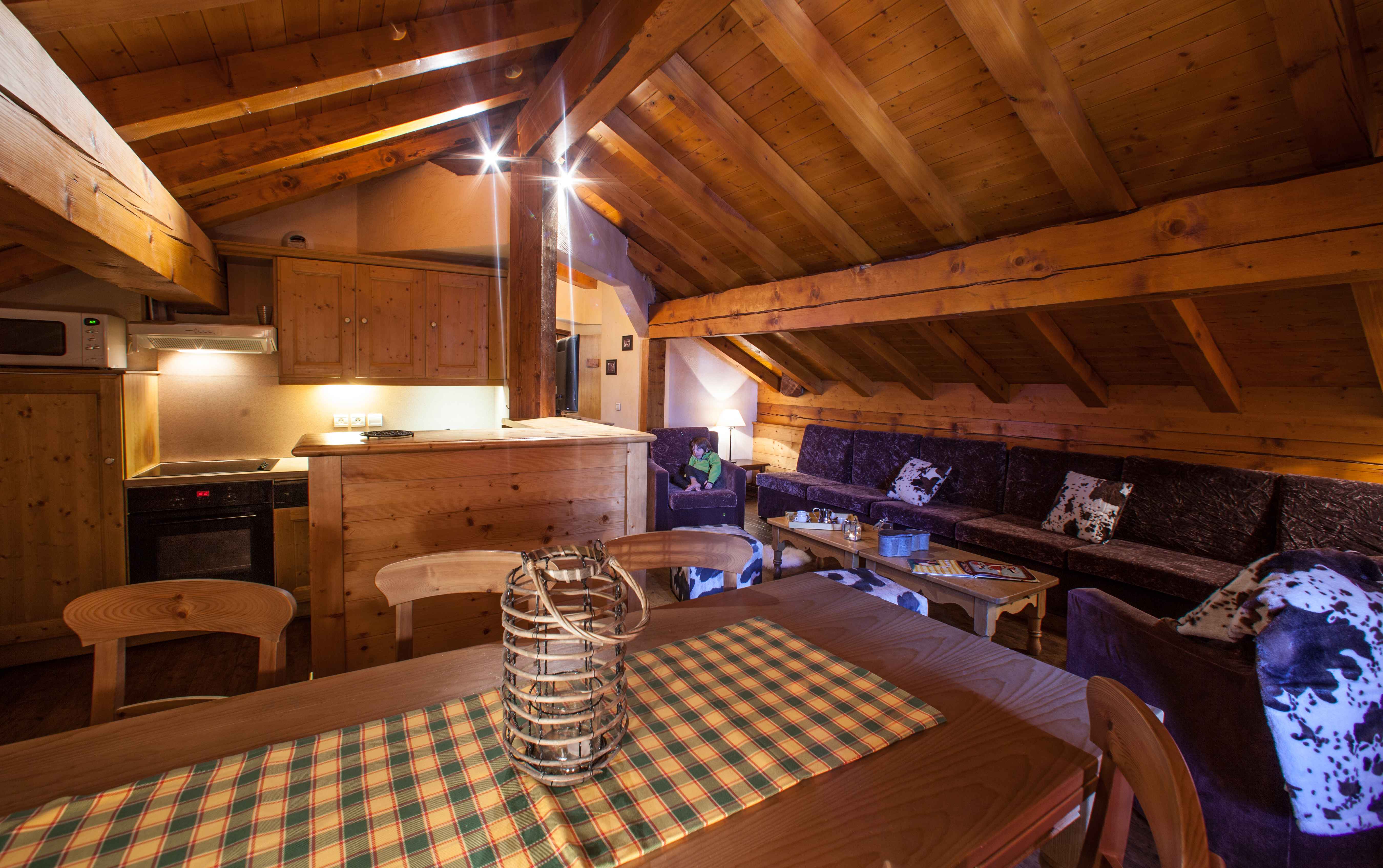 image Large open-plan lounge and dining area beneath exposed beams, ideal for group meals and downtime.