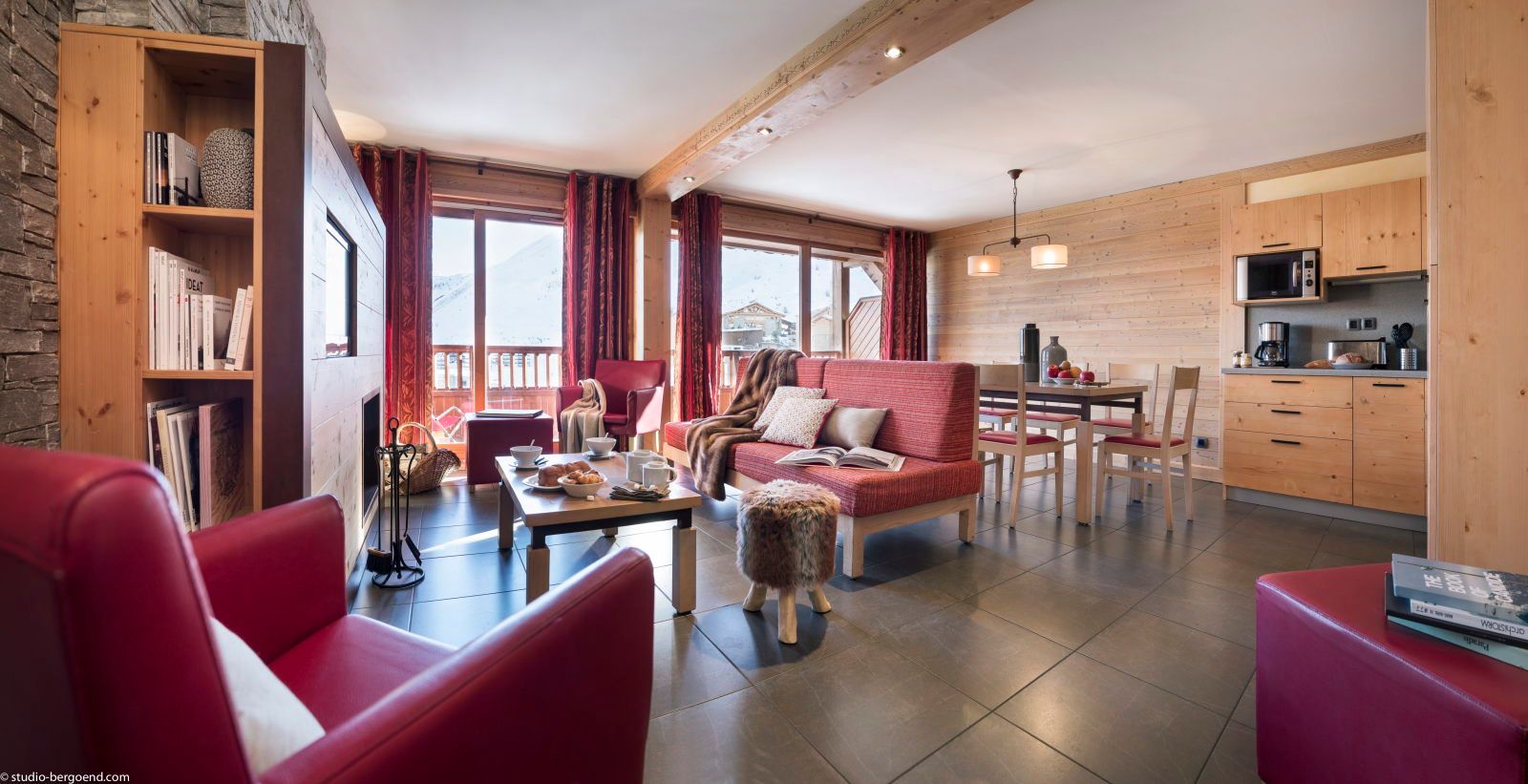 image Open living space with a sofa, dining table, and a stone fireplace as the centrepiece