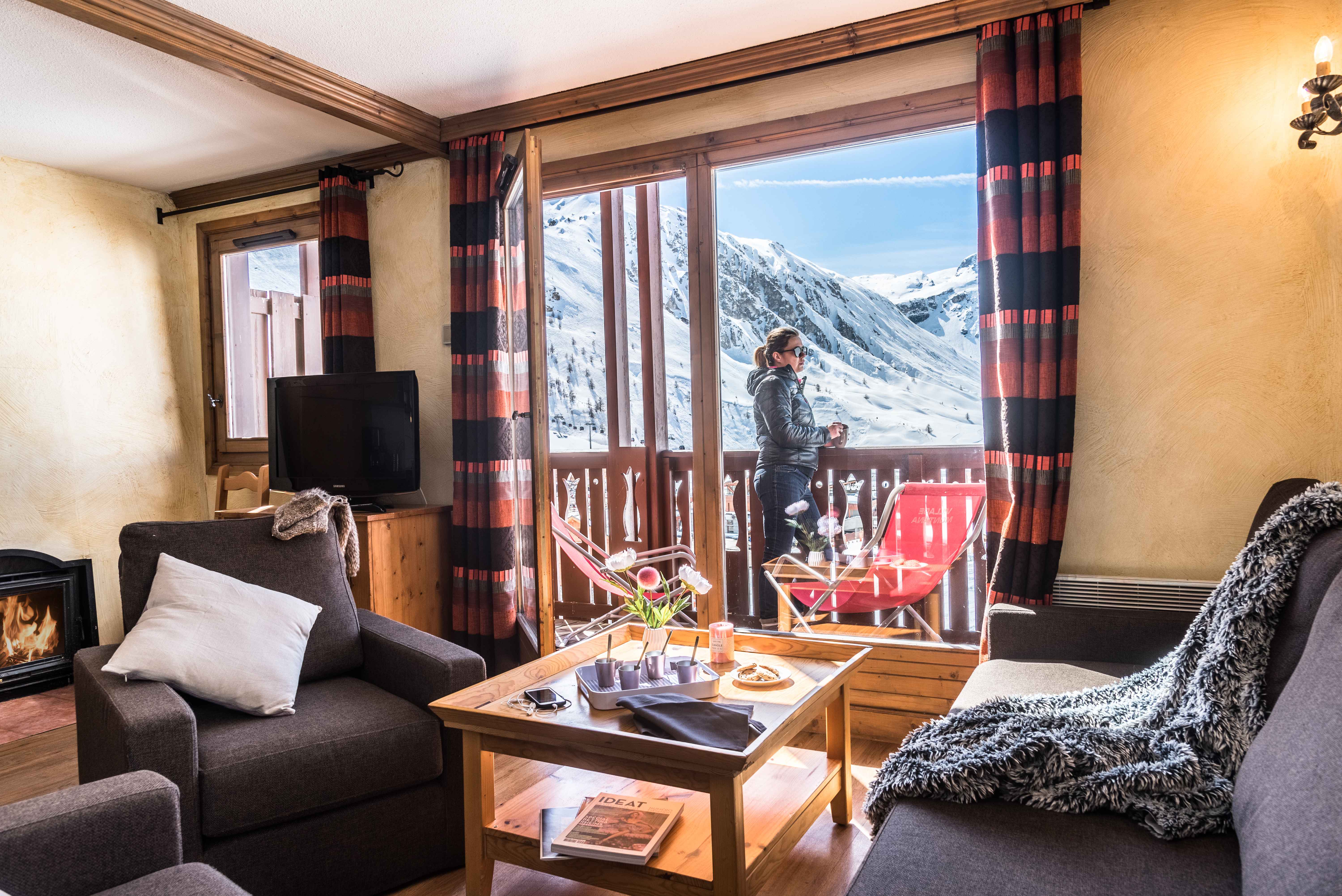 image Warm and inviting lounge with fireplace and access to a scenic balcony.