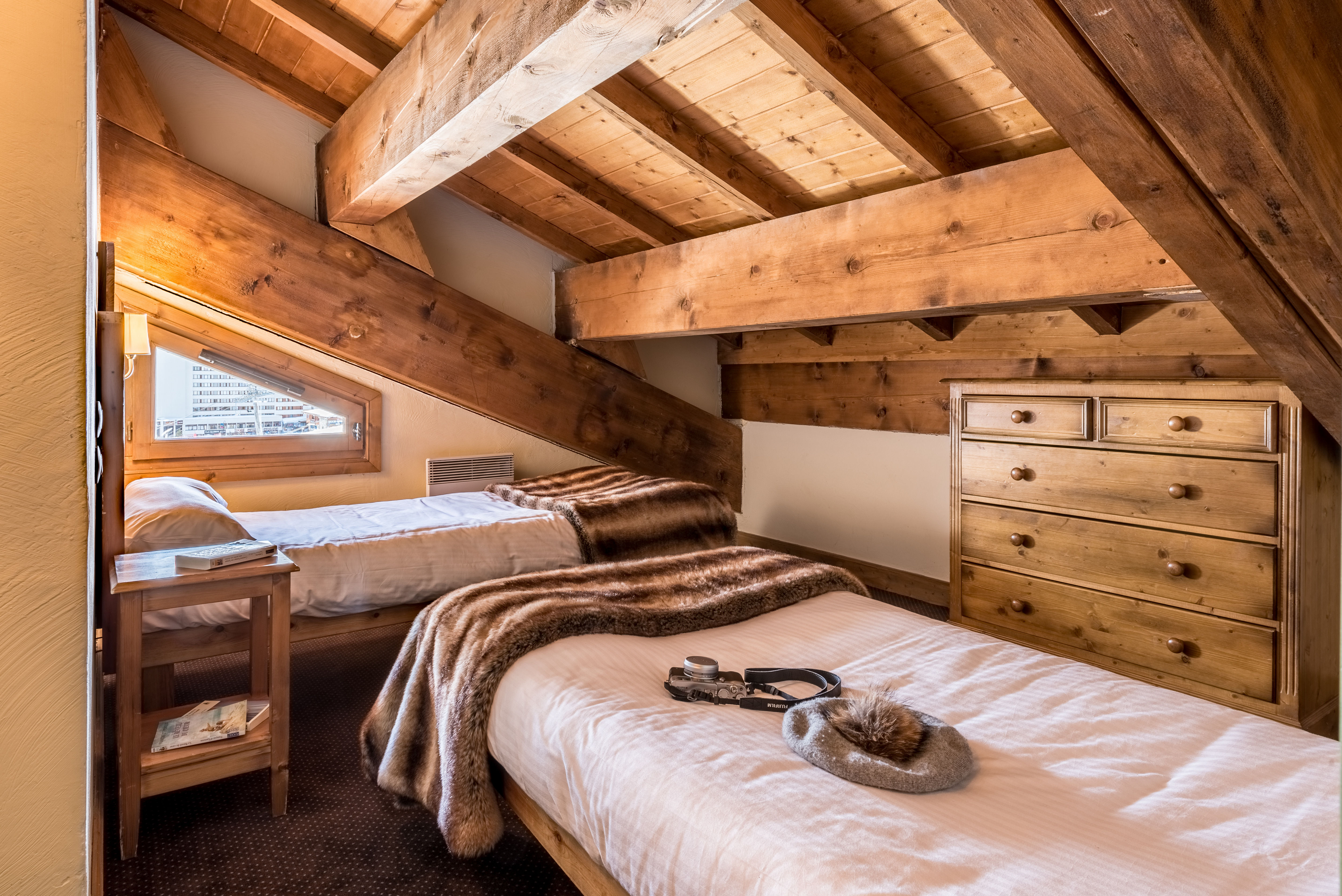 image Charming attic-style twin bedroom with sloped ceiling and natural light.