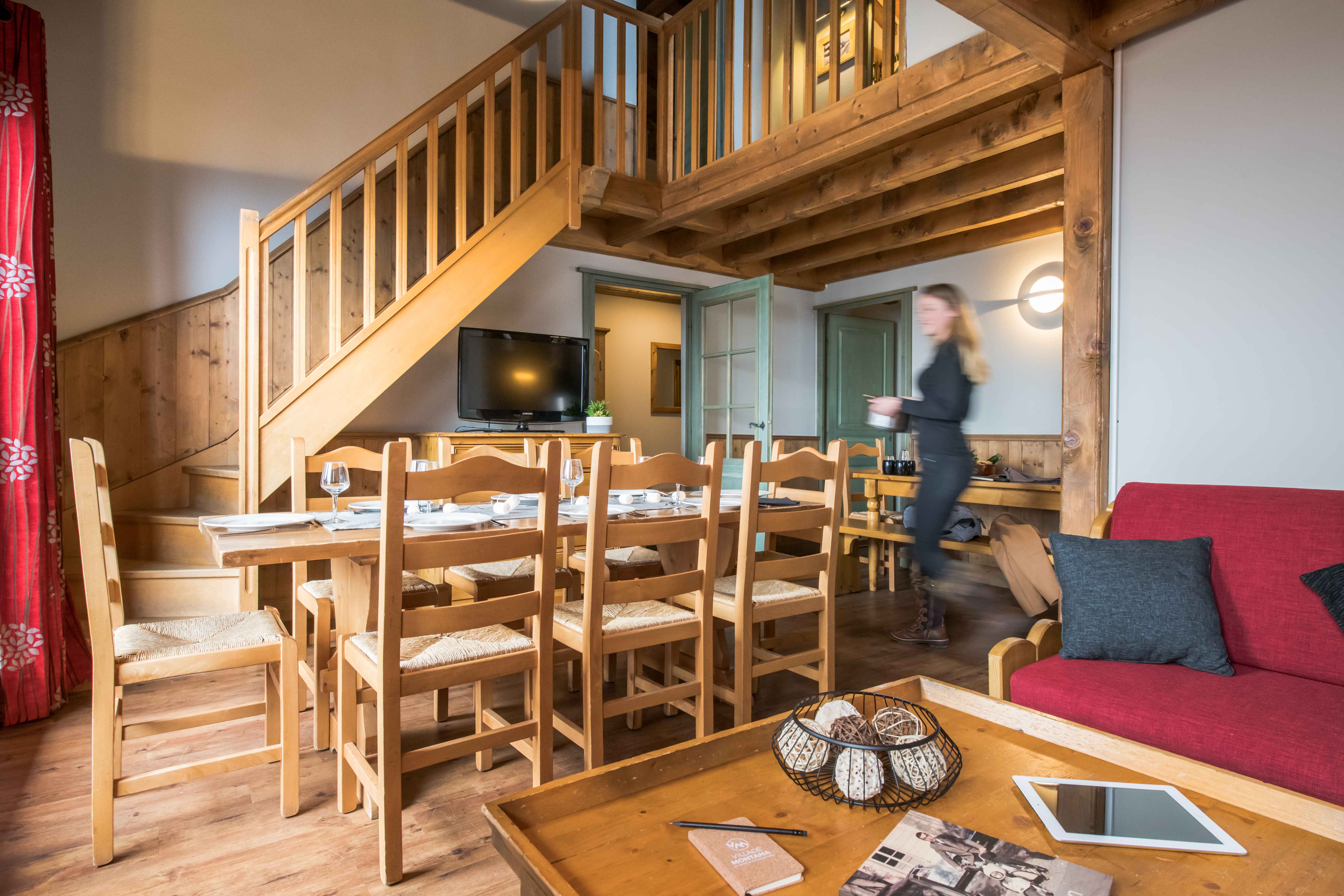image Duplex layout with wooden staircase, open-plan living, and dining area.