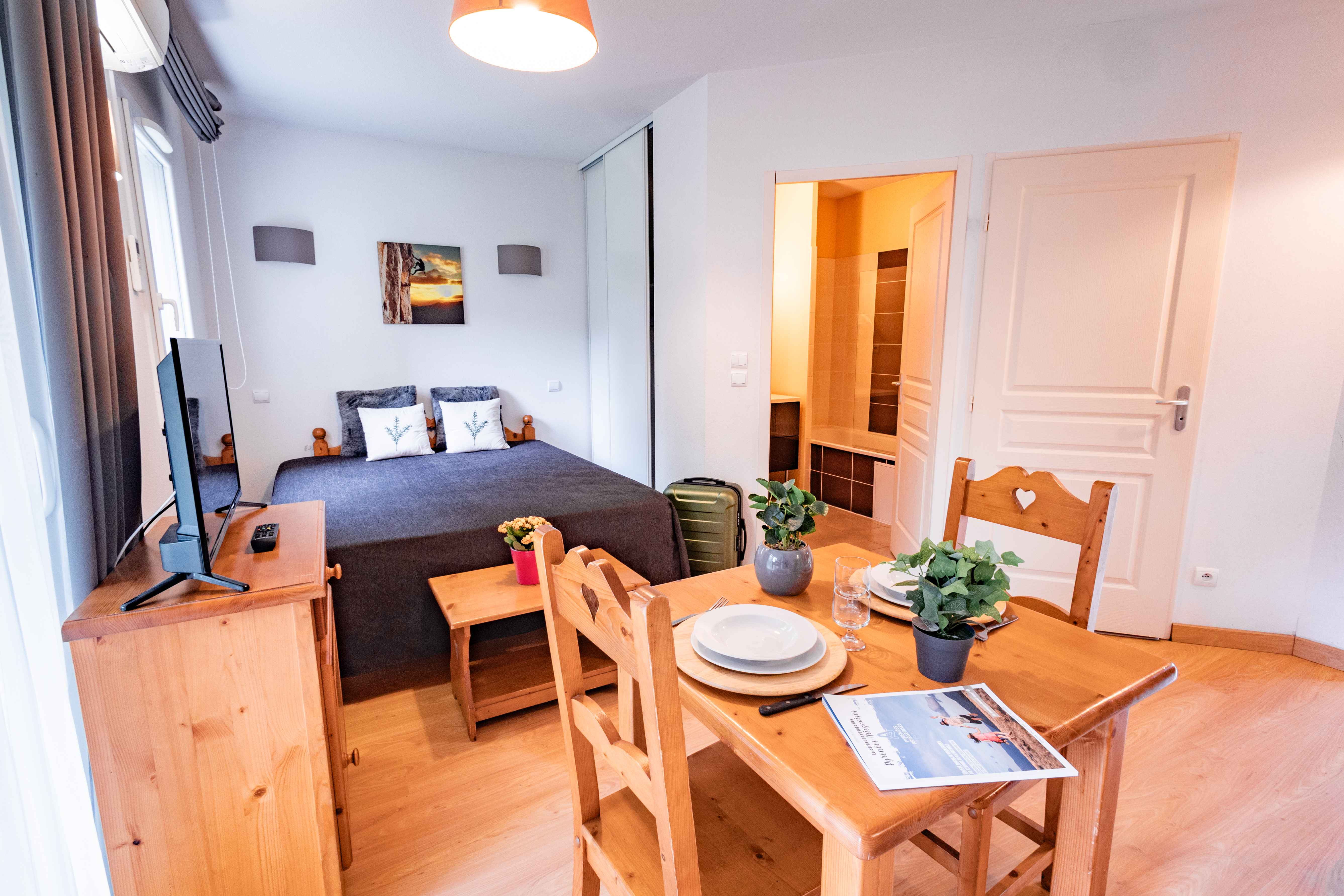 image Smart layout in this cosy studio blends sleep, dining, and cooking in one functional space.