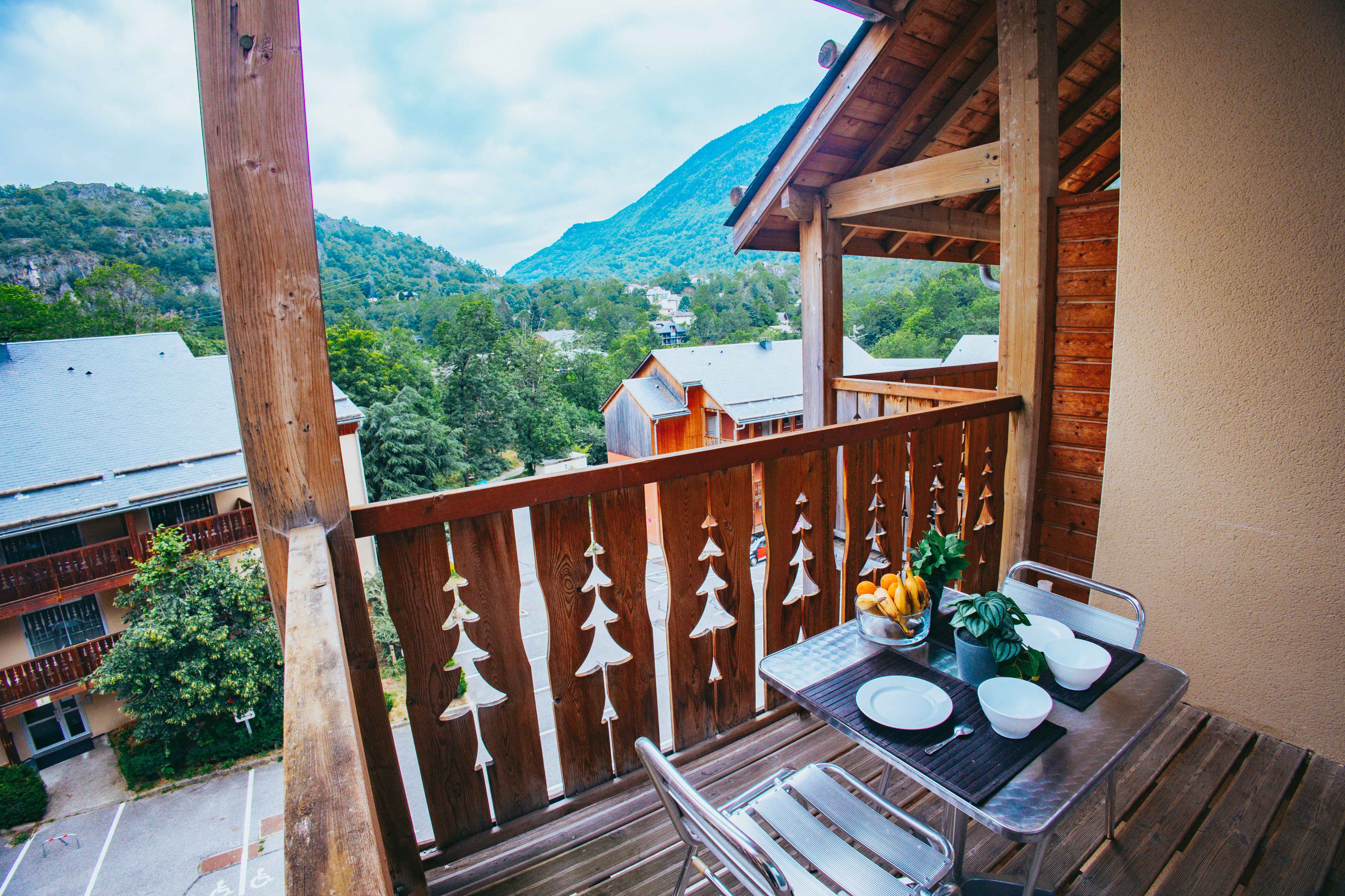 image Enjoy morning coffee on your balcony with serene mountain views—perfect for a group of four.