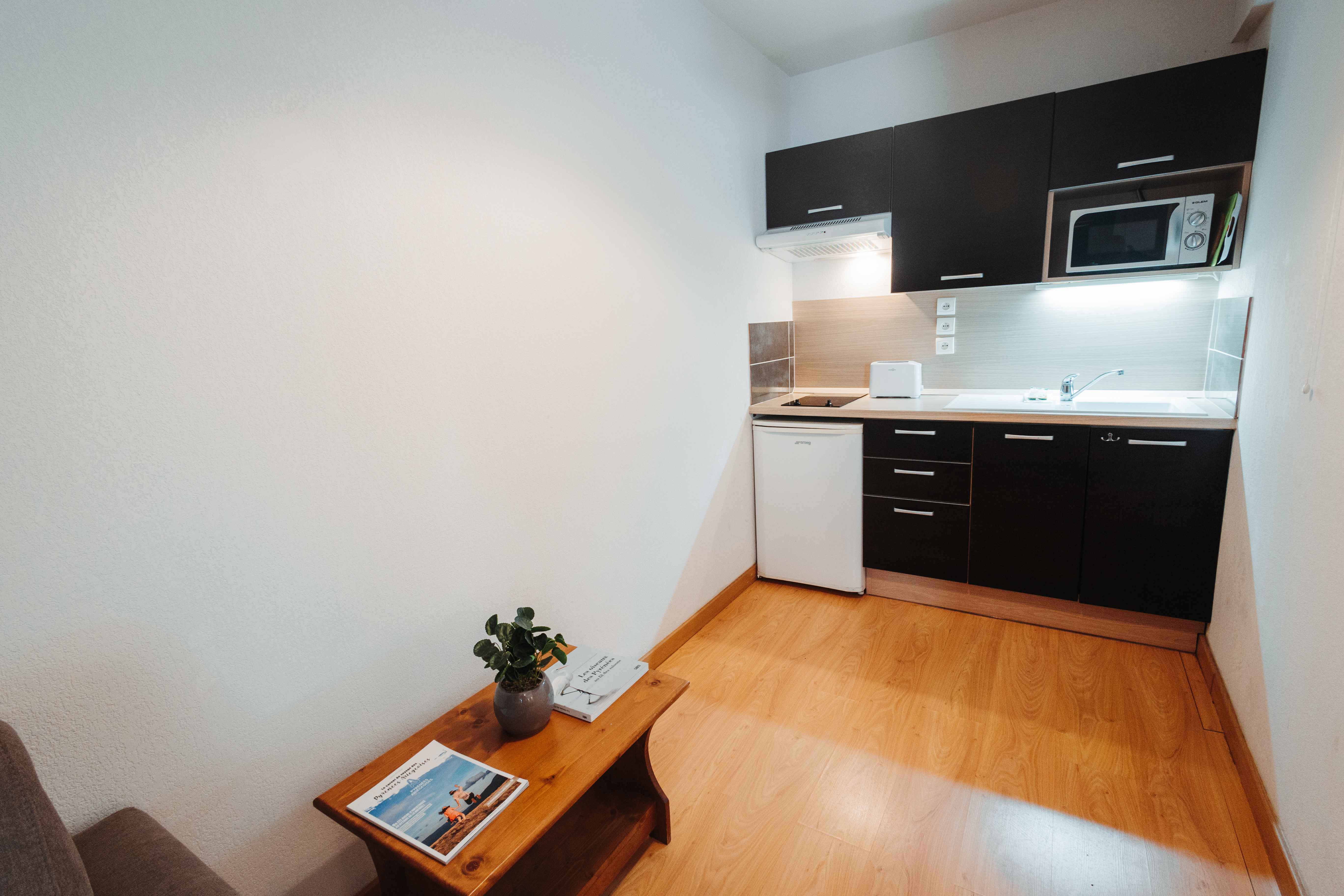 image Equipped kitchenette with hob, microwave, and coffee machine for simple, home-style meals.