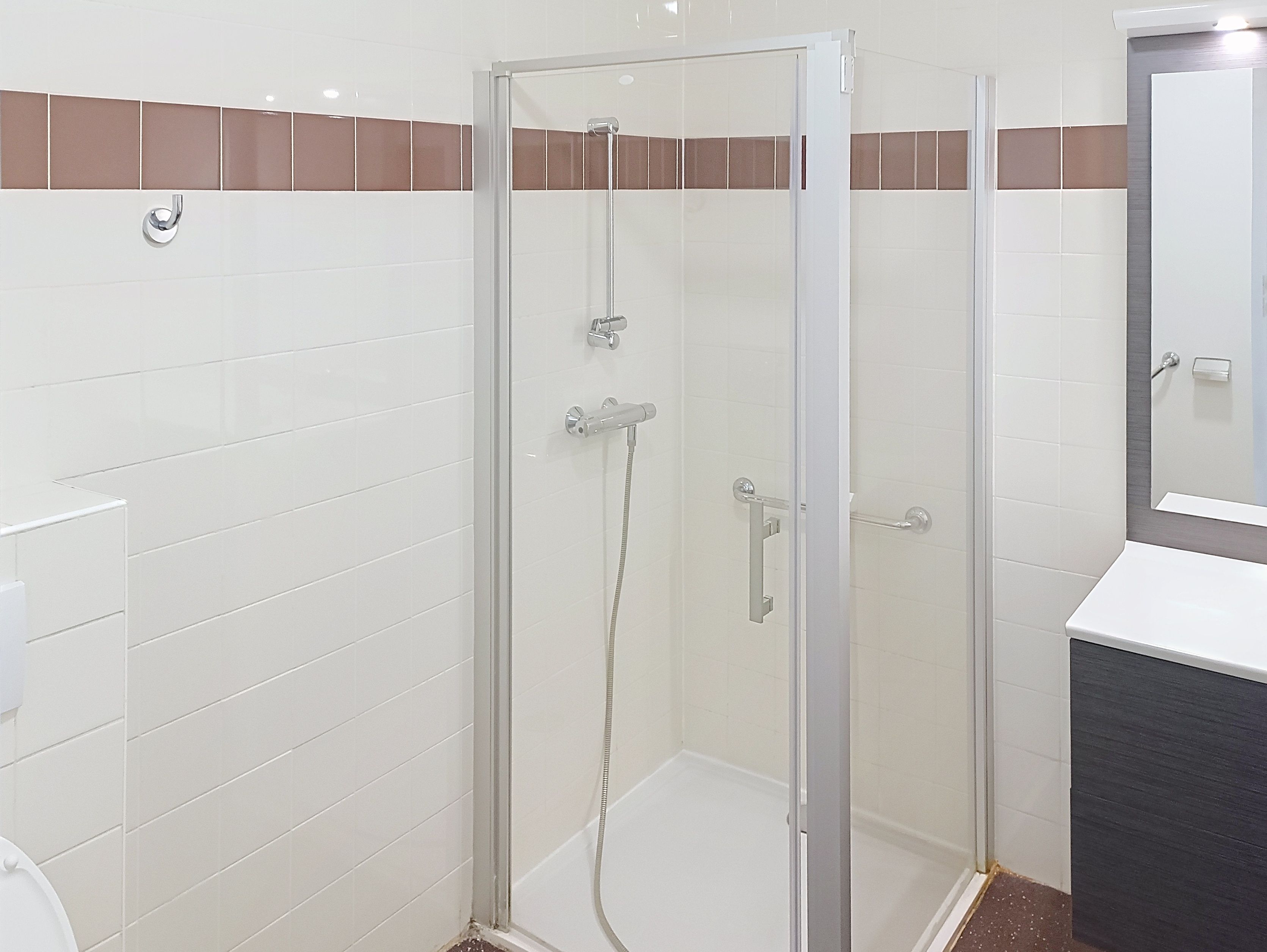 image Bathroom with shower, toilet, and mirror.