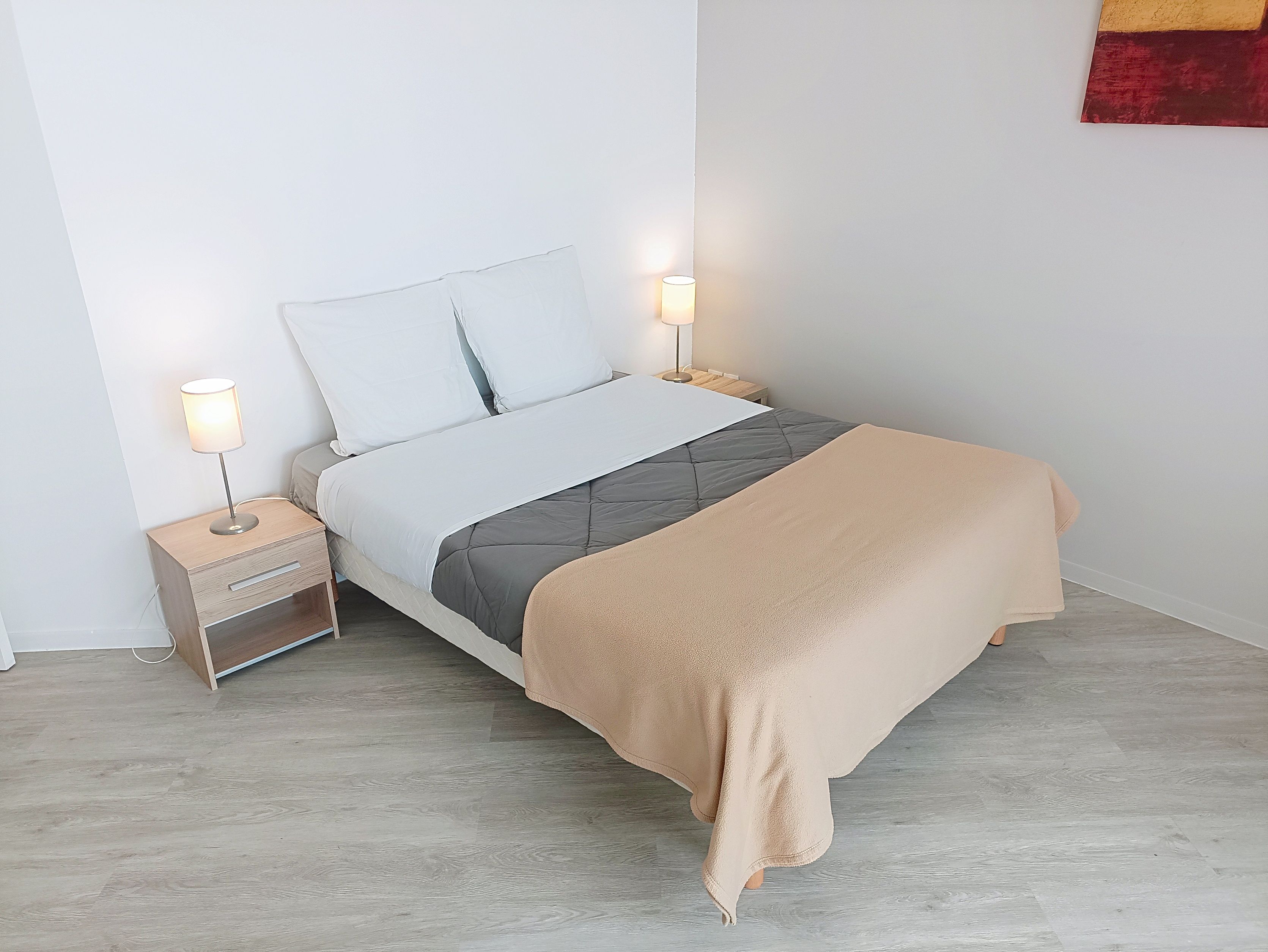 image Bed with bedside table and lamps.