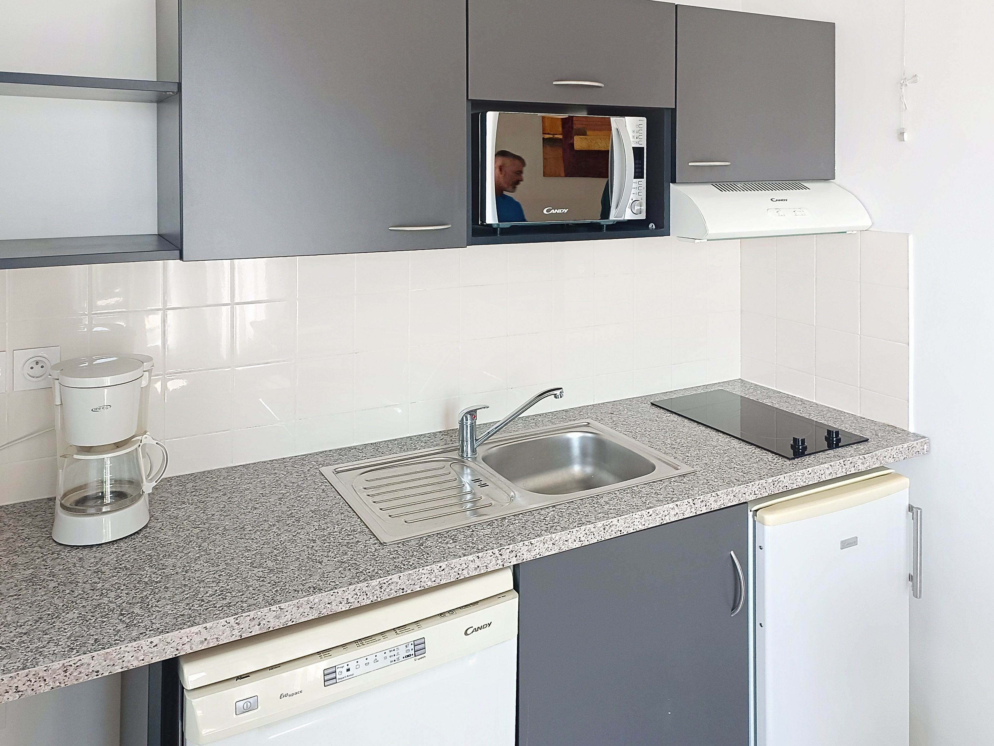 image Kitchen counter with coffee maker, sink, and appliances.