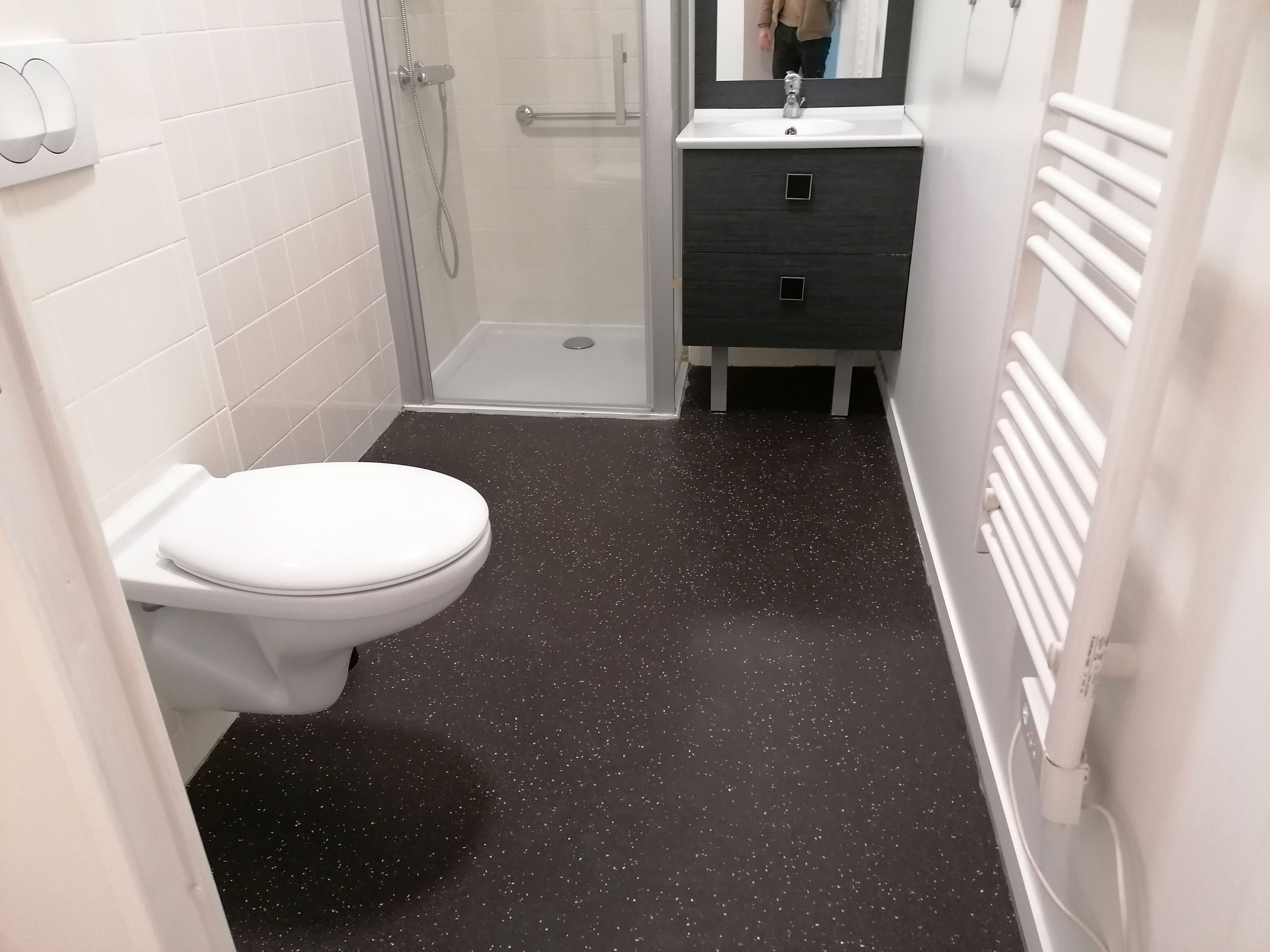 image A contemporary bathroom comes equipped with a spacious shower, modern fixtures, and a practical vanity for daily essentials.