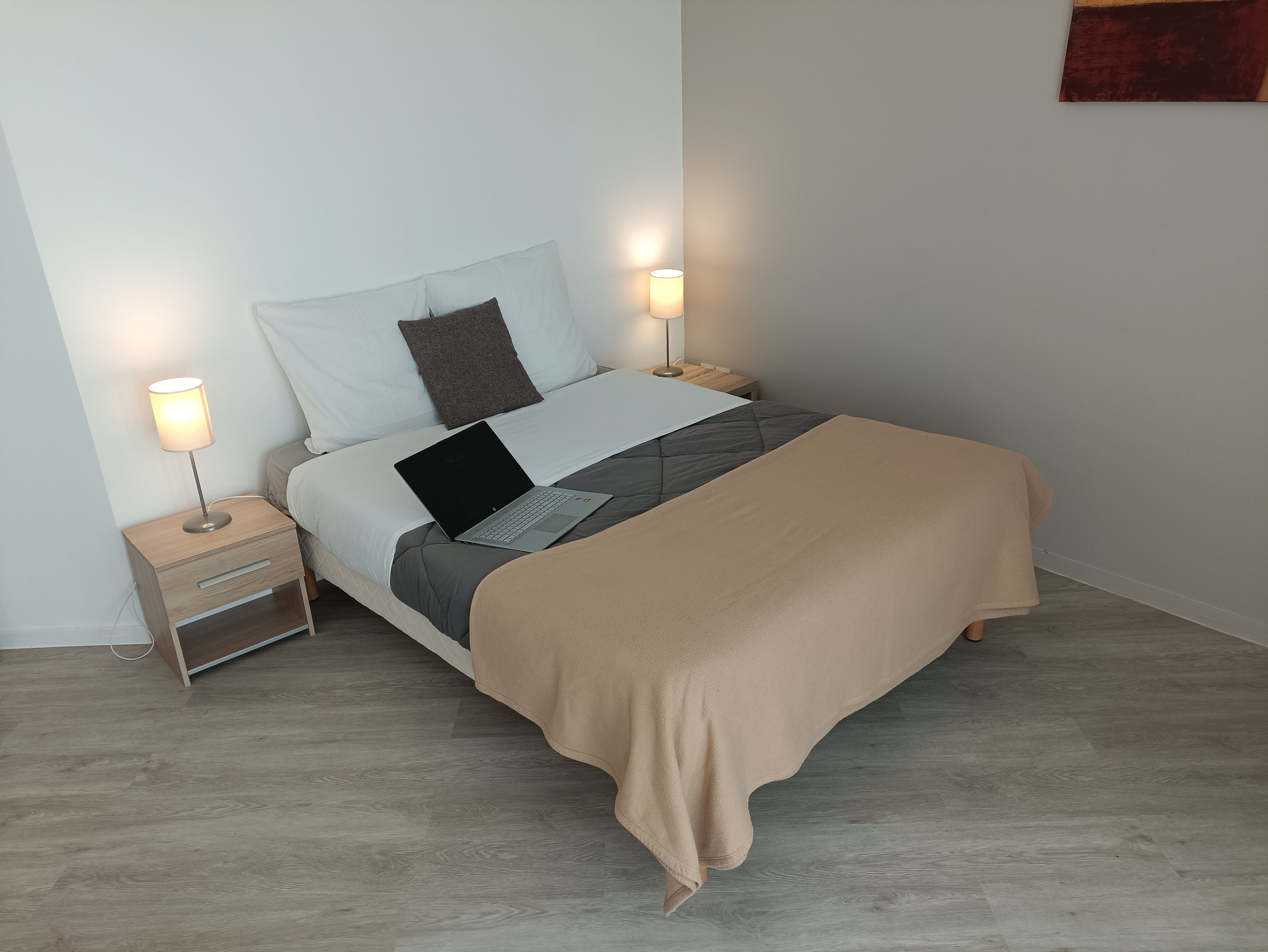 image Experience serenity in this cozy bedroom, furnished with a comfortable bed, soft lighting, and a workspace for your convenience.
