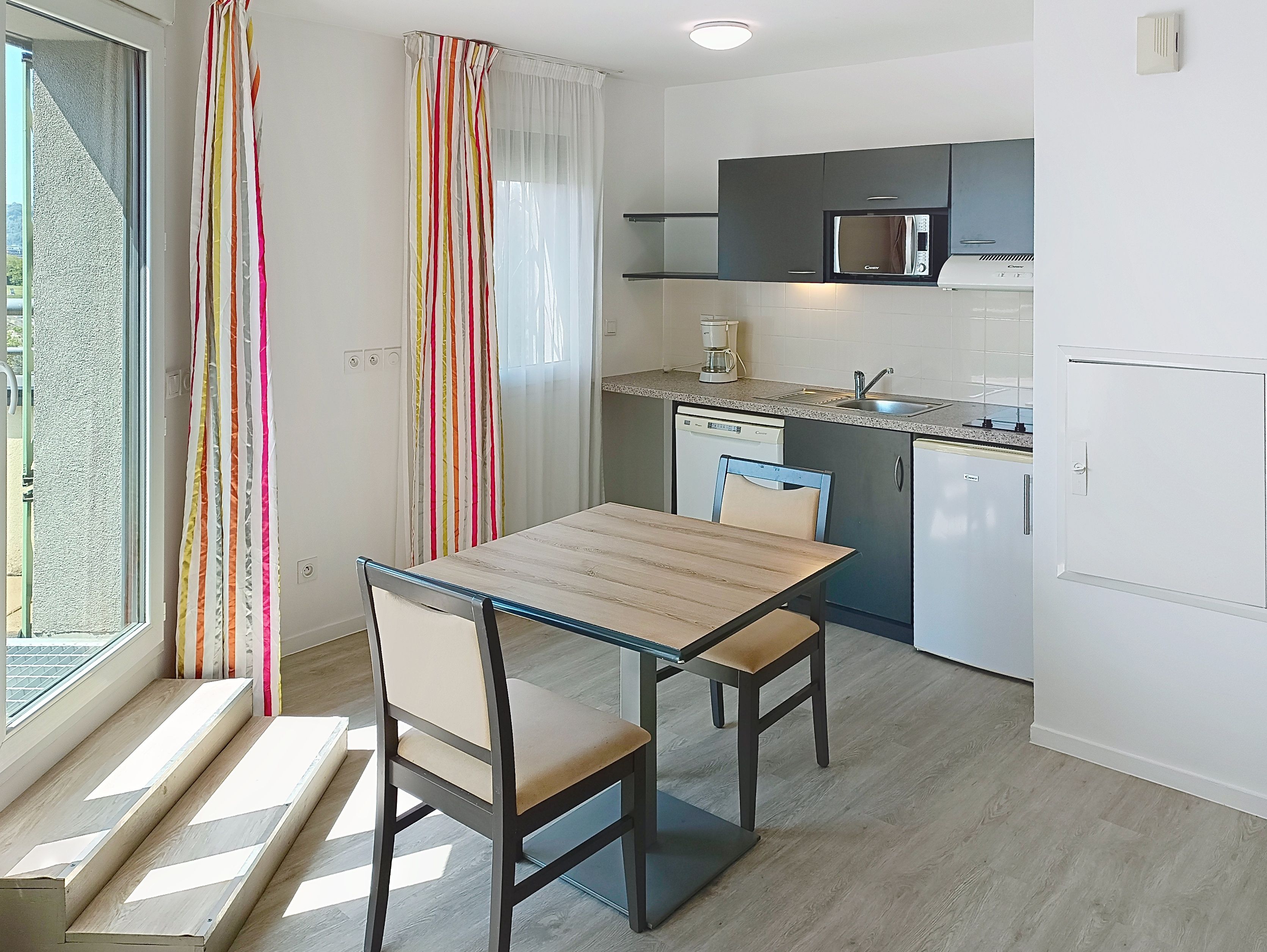 image This bright, inviting kitchen and dining area combines functionality with style, showcasing modern appliances and ample natural light.