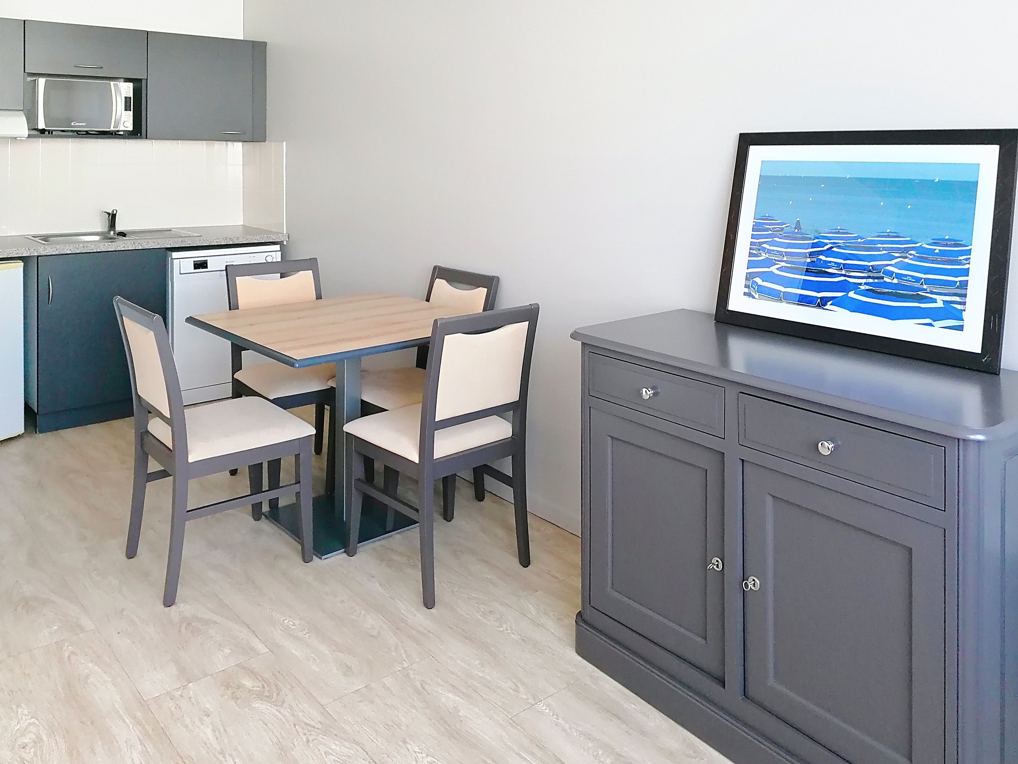 image Dining area with sideboard and framed artwork, part of the open plan living space.