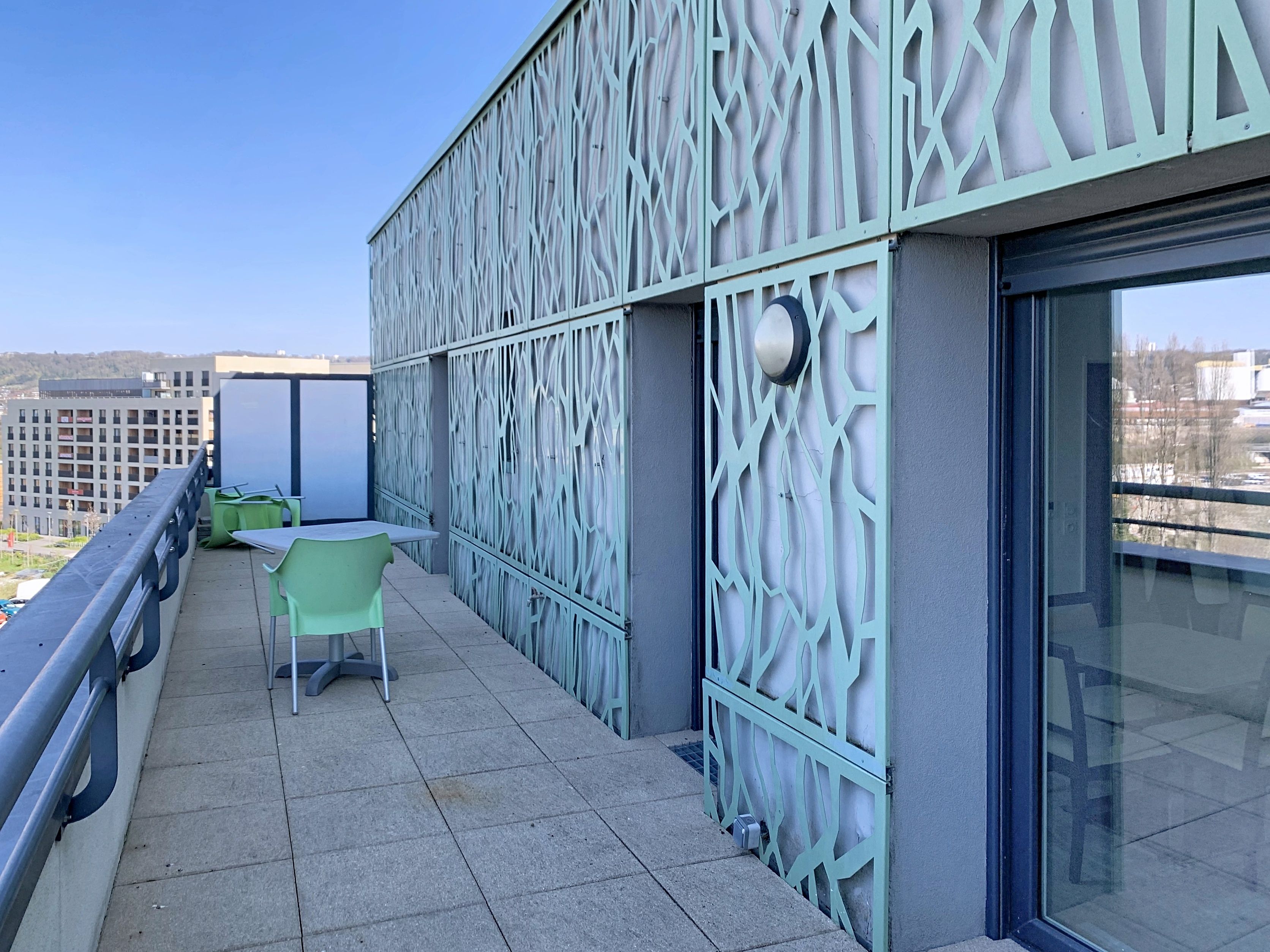 image Outdoor terrace with table and chairs, decorative building exterior.