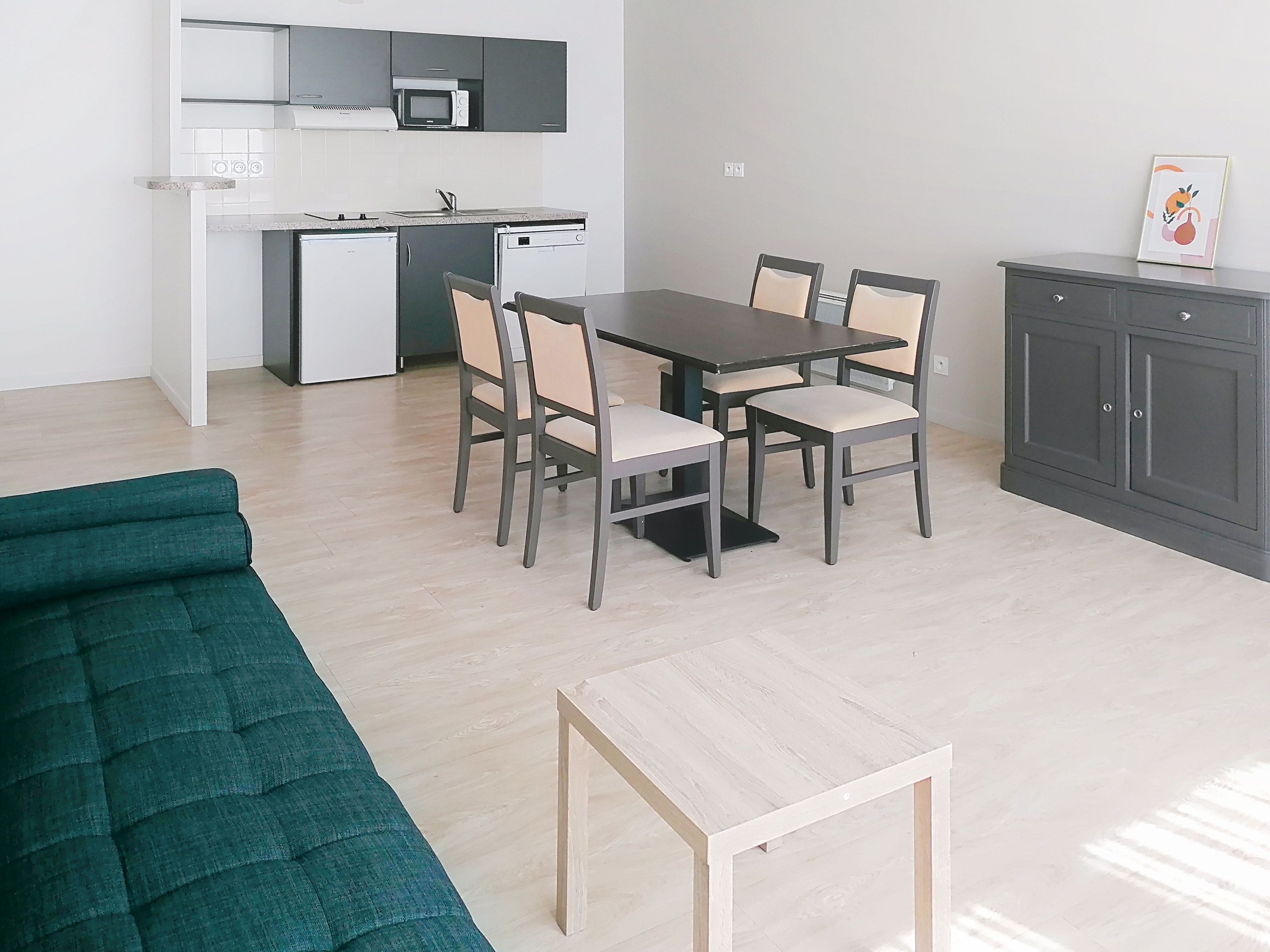 image Kitchen area with countertop and dining table, gray cabinets.