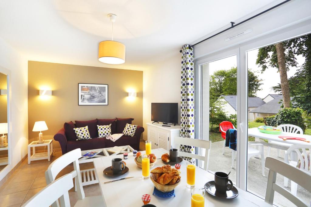 image The cozy living area boasts a bright atmosphere with a dining table, a comfortable sofa, and views of the outdoor terrace.