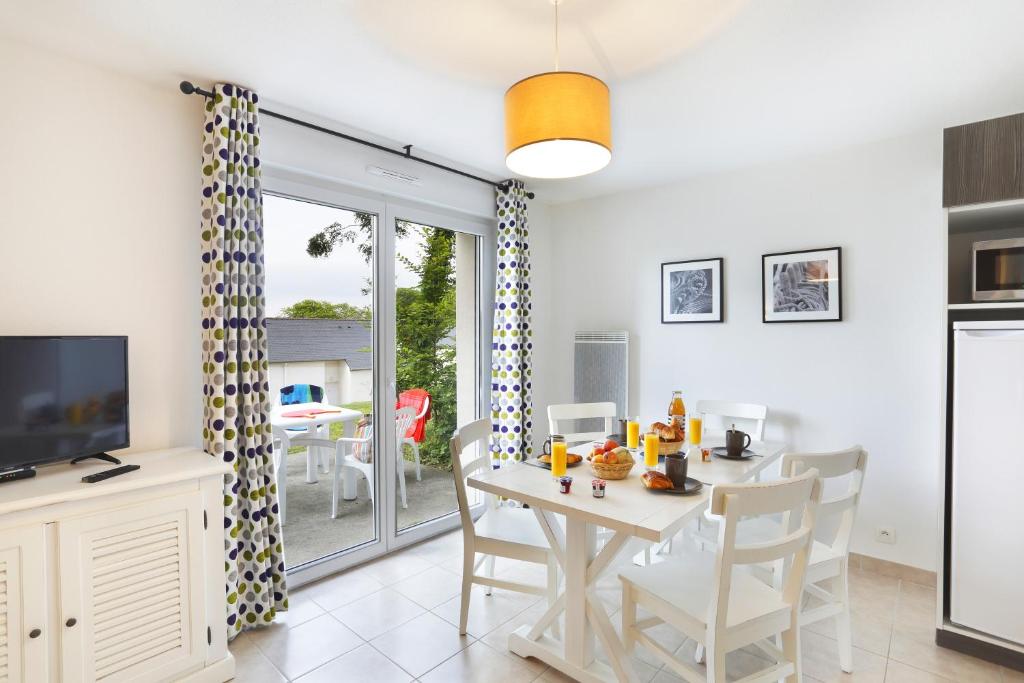 image Bright and inviting dining area with a view of the private terrace, showcasing a cozy breakfast setup.