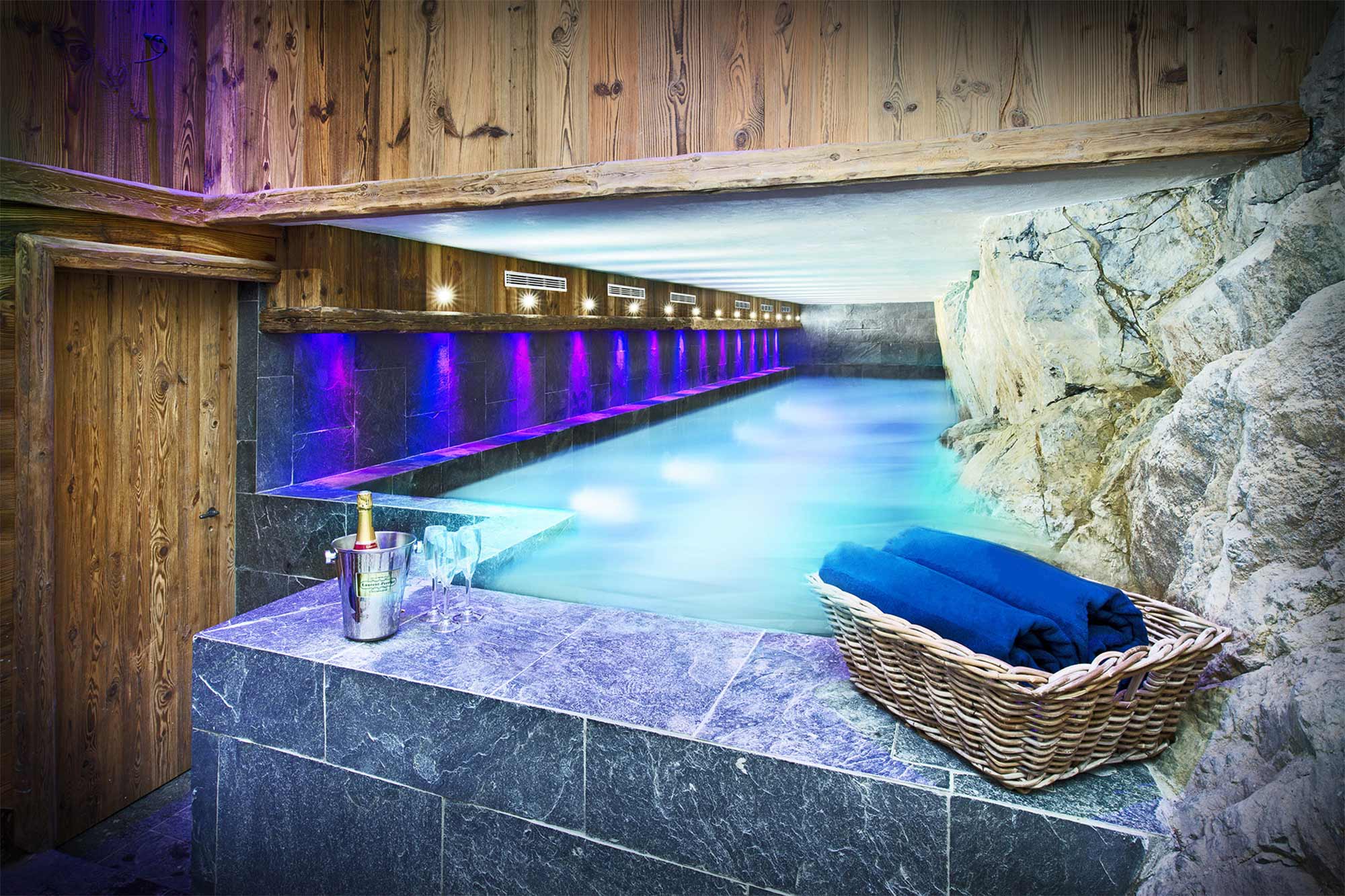 image Unwind in the invigorating indoor pool, illuminated by spa lighting that transforms relaxation into an enchanting experience within the serene ambiance of Chalet Genepy.