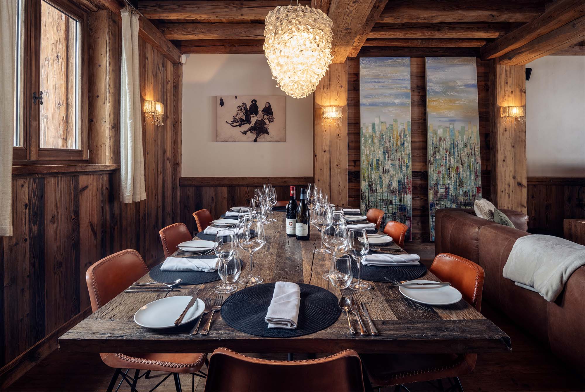 image Gather your friends and family around the expansive dining table, elegantly adorned for memorable meals amidst the cozy and chic alpine atmosphere of Chalet Genepy.