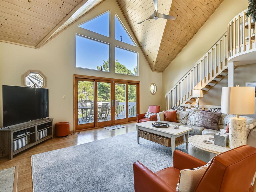 image Stylish living area featuring a fireplace, vaulted ceilings, and vibrant accent chairs.
