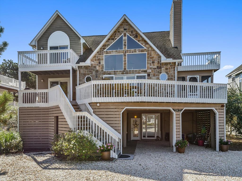 image Stunning front view of the 6-bedroom coastal retreat with multiple decks and elegant design.
