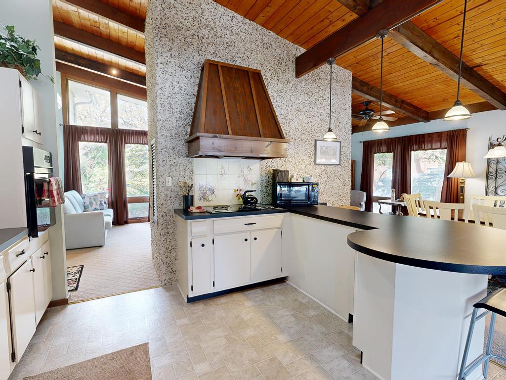 image Warm wood accents and a sunny living space invite memorable family gatherings and cooking adventures.