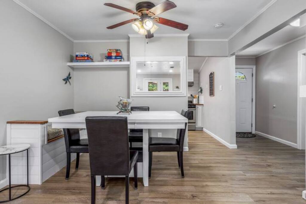 image Charming dining space with a spacious table and cozy bench seating, complemented by natural light from nearby windows.