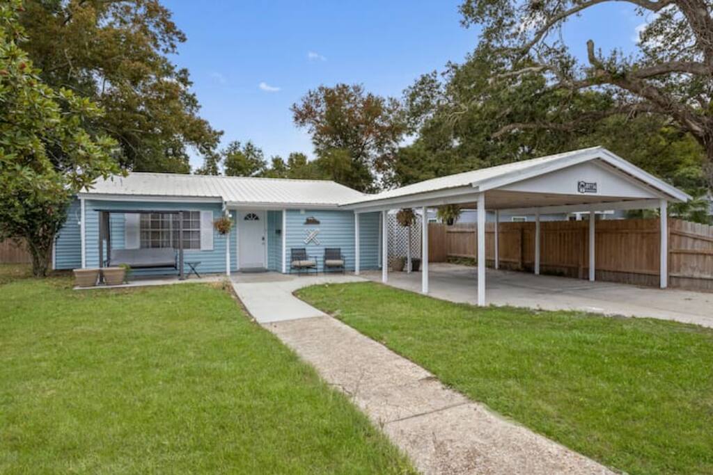 image The charming exterior of this beachside home showcases its inviting blue facade and spacious yard, perfect for outdoor gatherings.