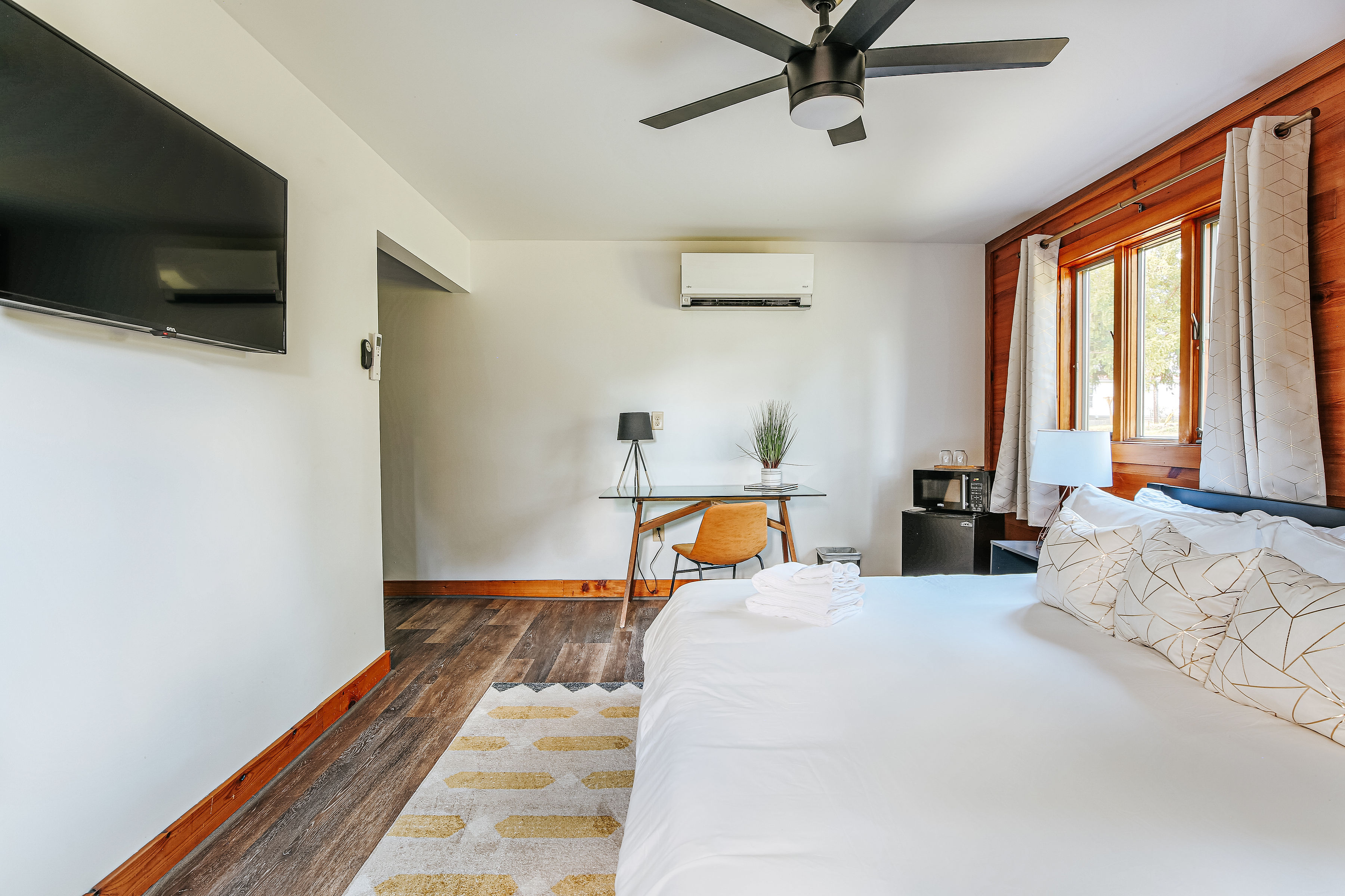 image Modern amenities include a work desk, kitchenette, and smart TV.