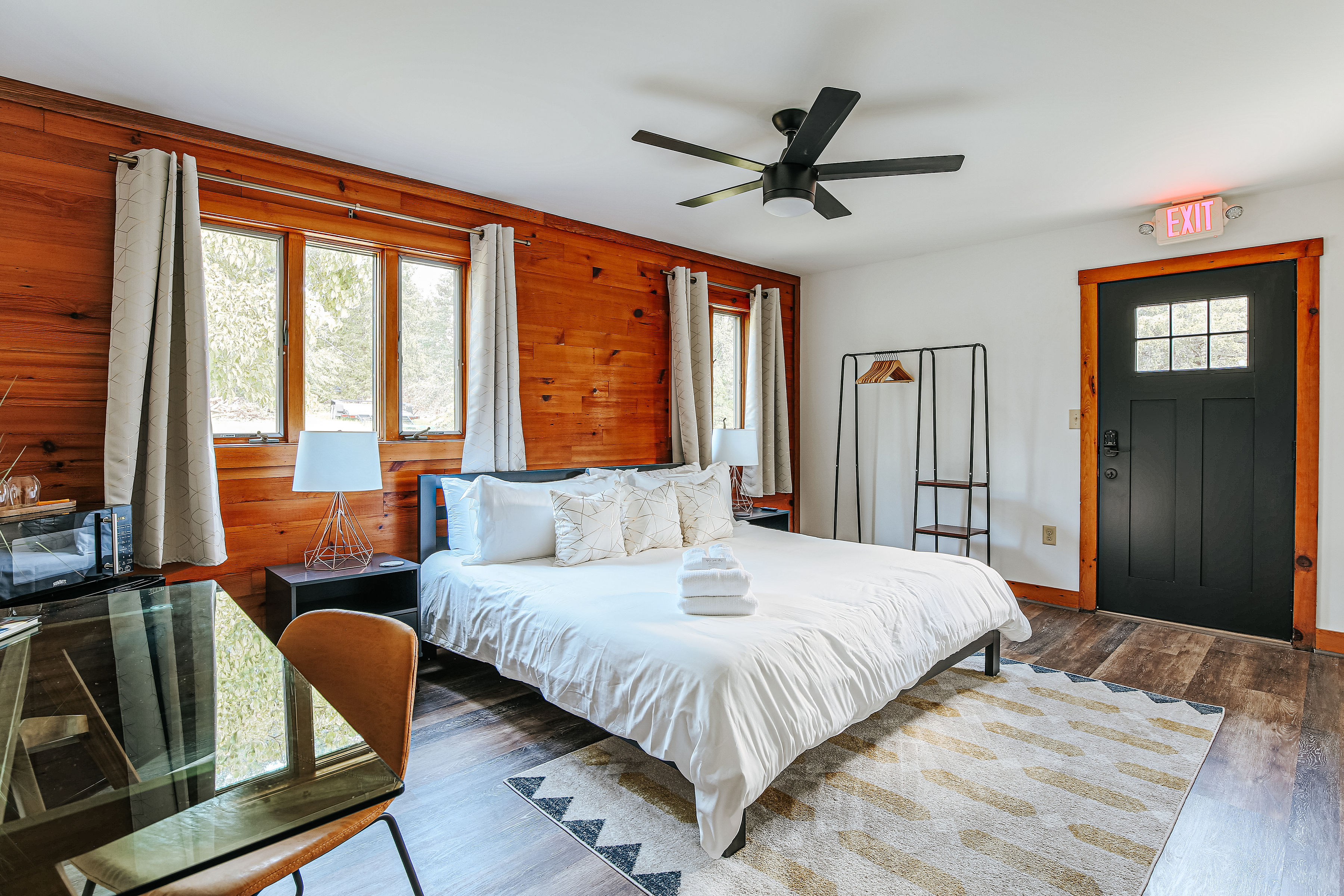 image Cozy ADA-accessible bedroom with a king bed, desk, and large windows for natural light.