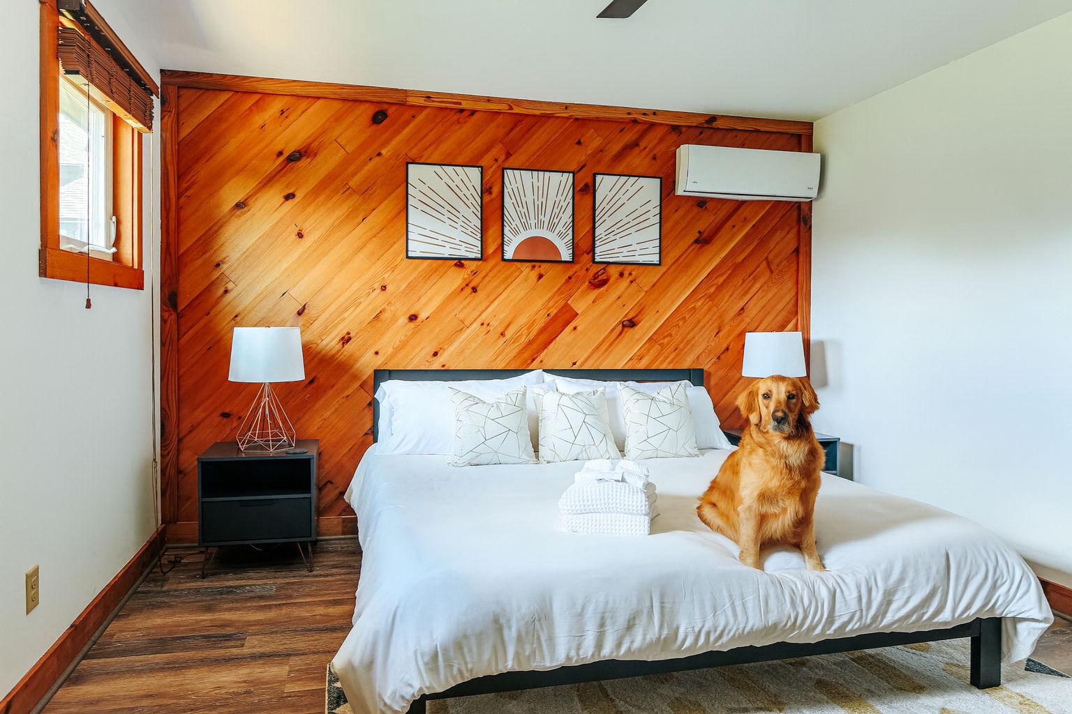 image Cozy king suite with wood accents and plush bedding where your furry best friend can snuggle right in!
