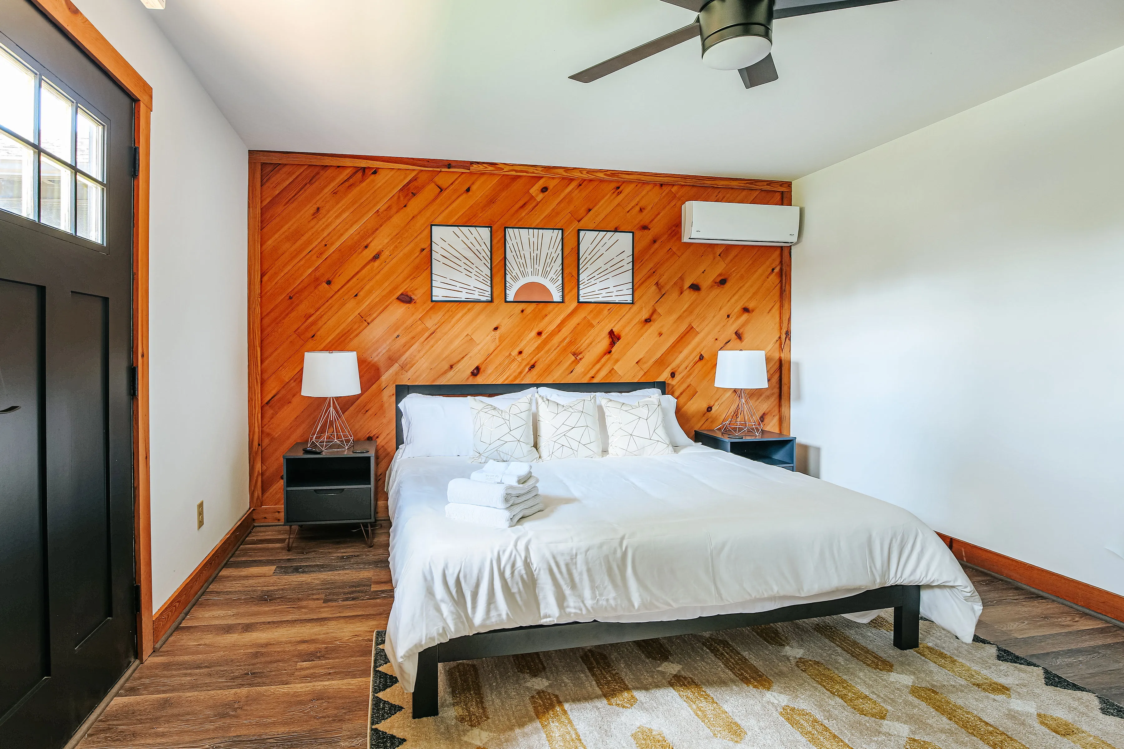 image Serene king bed framed by wood accents and warm lighting.