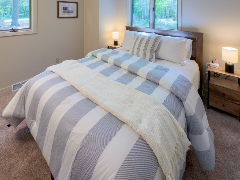 image Restful bedroom featuring soft striped bedding and gentle lighting, offering a serene retreat for a great night’s sleep.