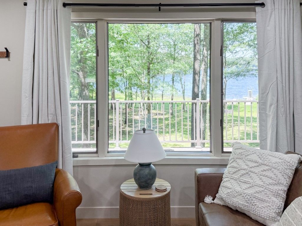 image Peaceful lake view from the comfort of your living room, framed by large windows that invite the beauty of Deep Lake indoors.