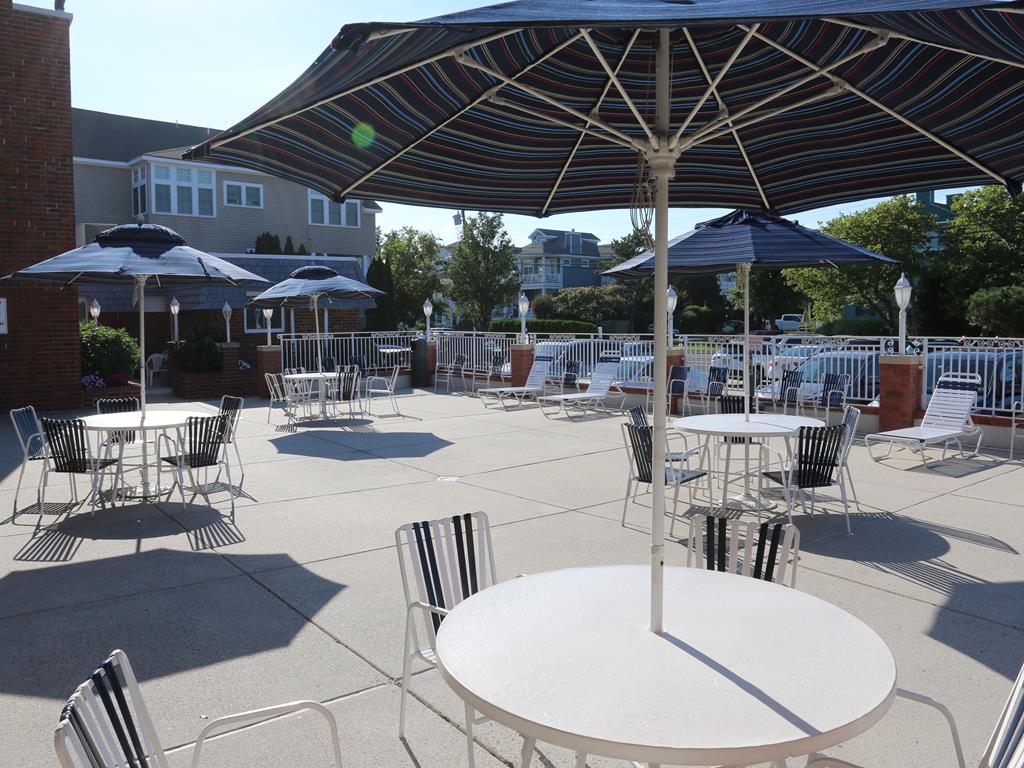 image Outdoor patio with ample seating and umbrellas, perfect for relaxing between beach visits and BBQ nights.