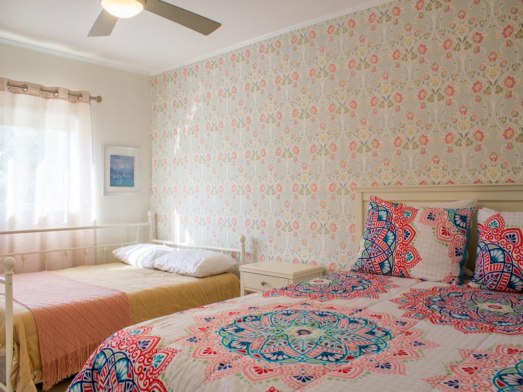 image Bright bedroom with queen bed and full bed with twin trundle, ideal for families or friends on a Cape May beach getaway.