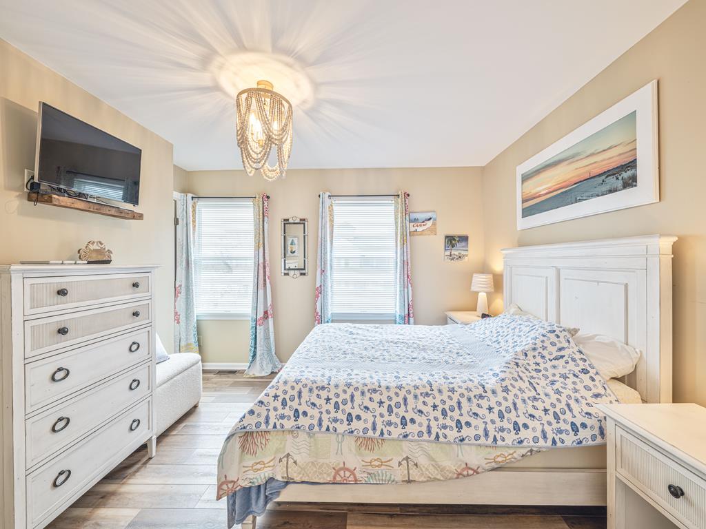 image Tranquil primary bedroom with queen bed, Smart TV, and abundant natural light.