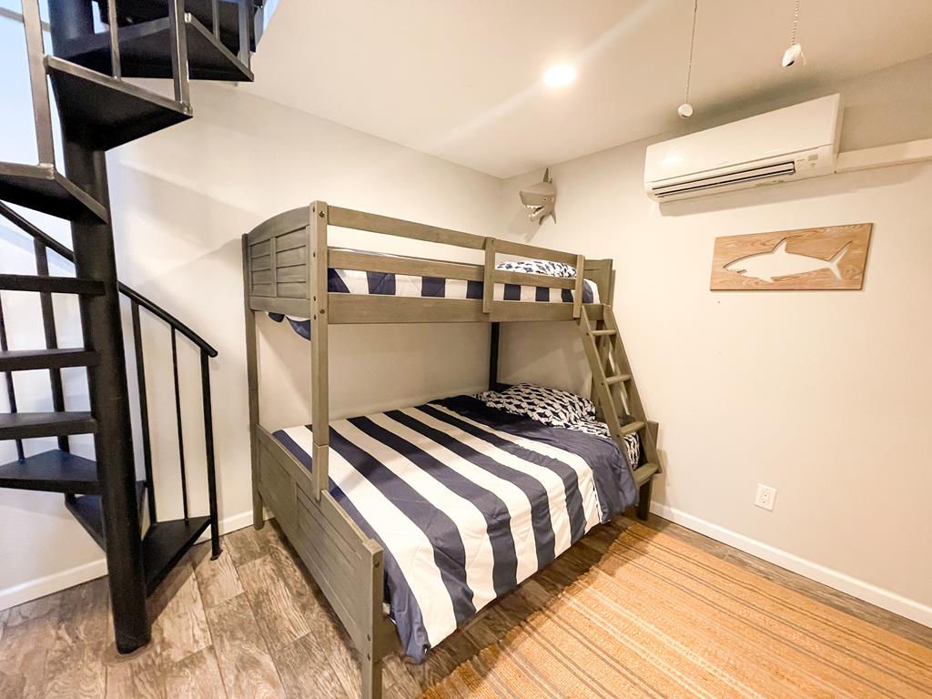 image Another view of the cozy bunk room with spiral staircase access and ample space for relaxation.