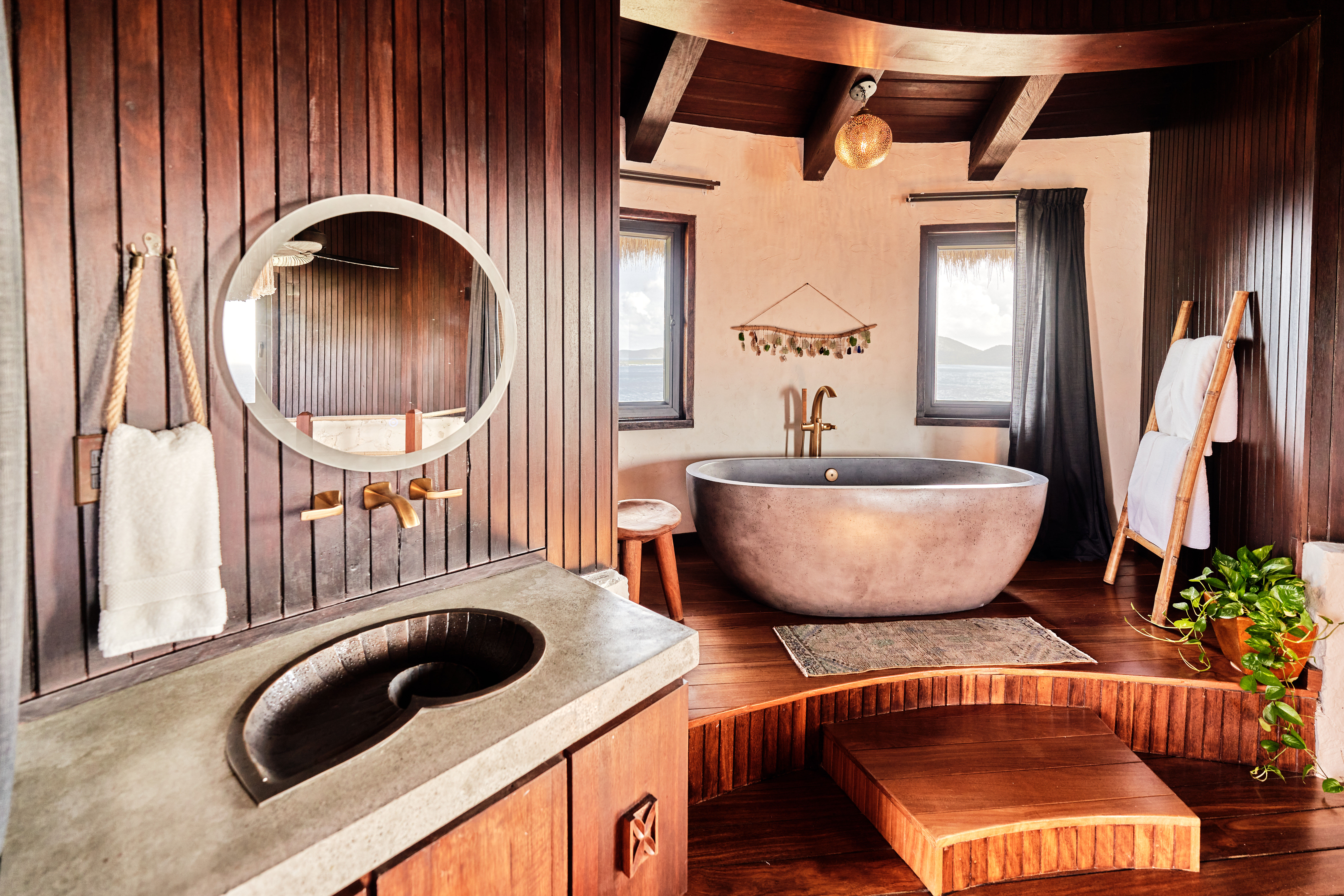 image The elegantly designed bathroom boasts rich wooden accents, a round soaking tub, and stunning views from every corner.