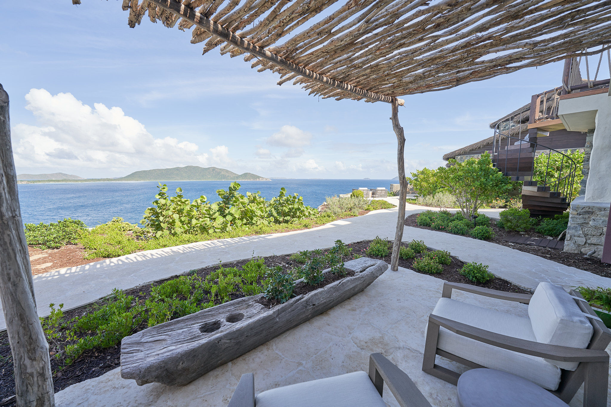 image Shaded patio with cozy seating and sweeping views of the ocean.