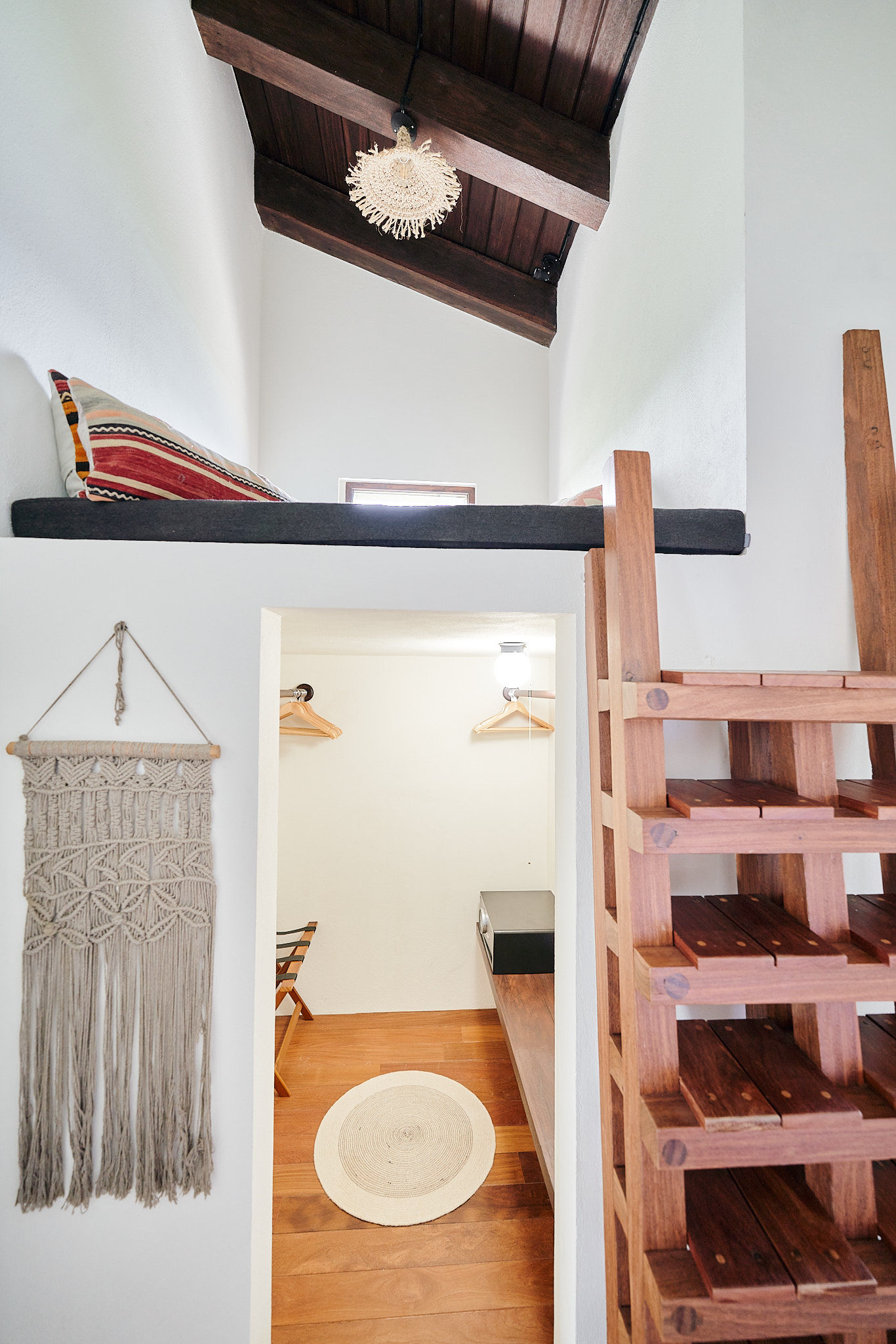 image Unique loft access with handcrafted wooden staircase and boho details.