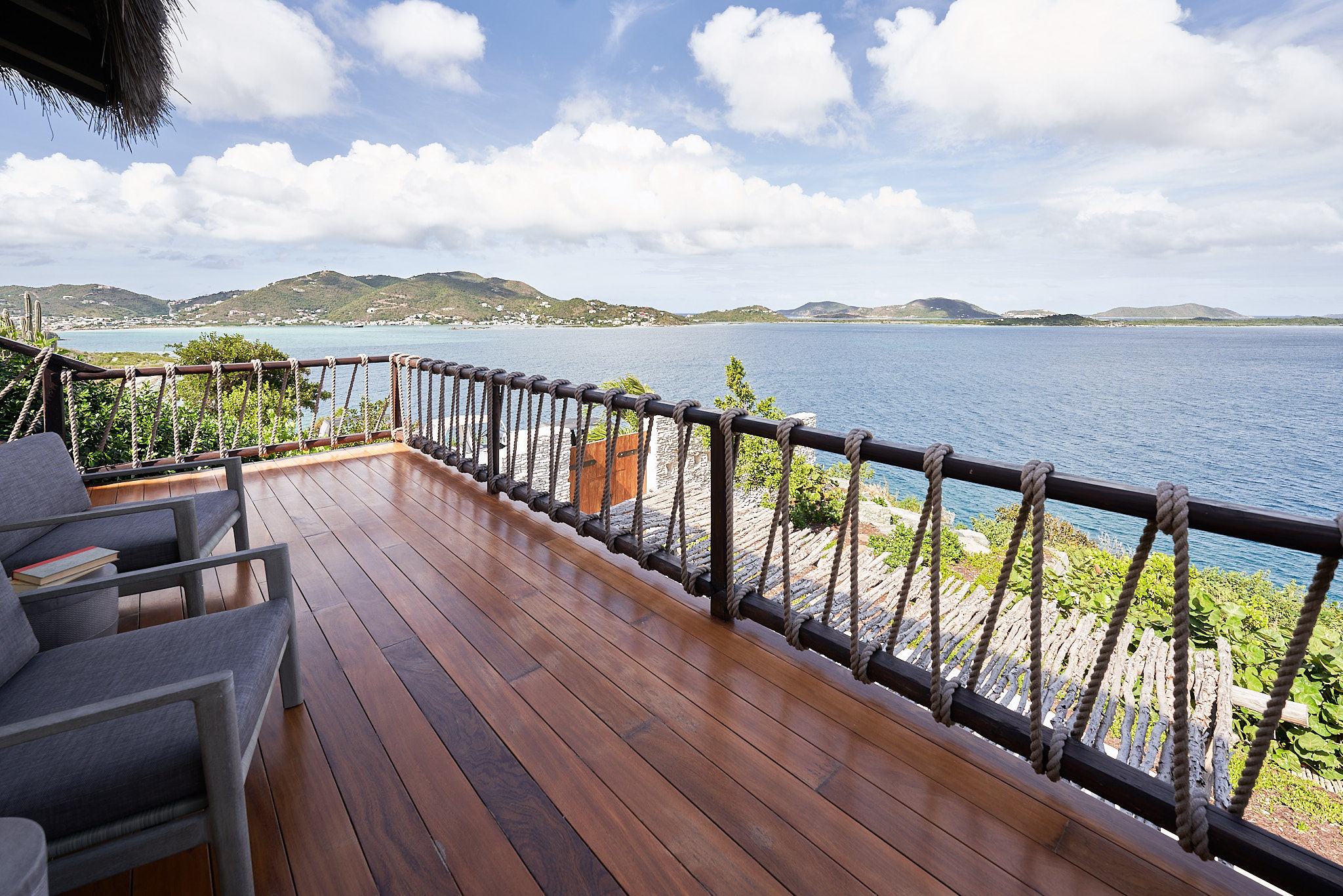 image Expansive wooden deck with seating and panoramic bay views.