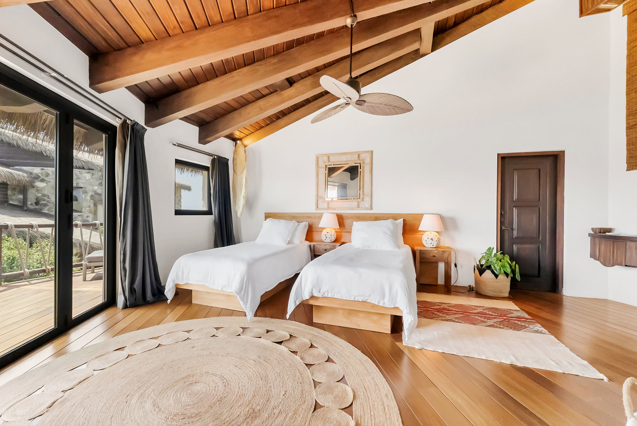 image Spacious bedroom with twin beds, exposed beam ceiling, and relaxing island-inspired décor.